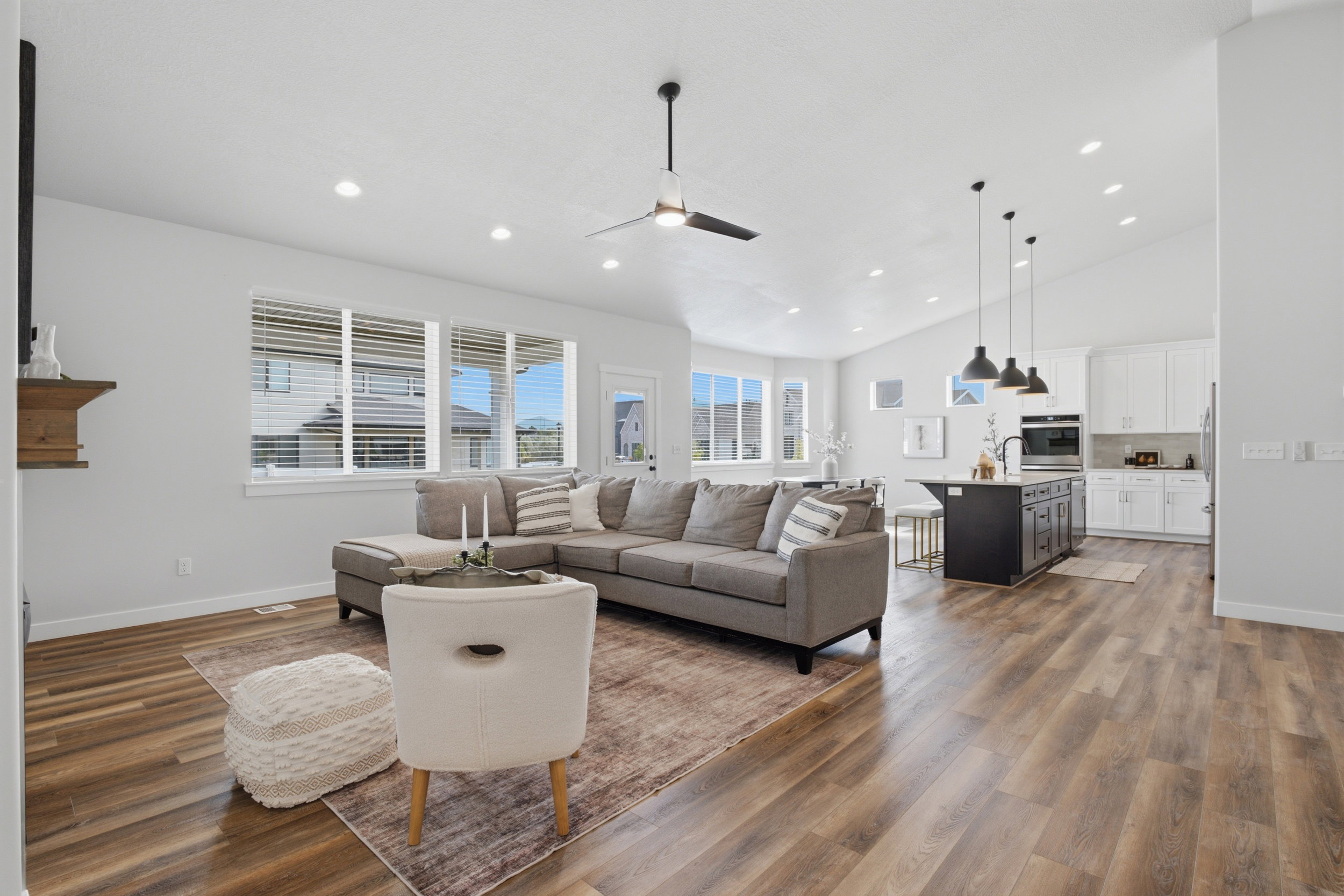 Open-concept living space featuring wood-finish flooring, recessed lighting, and a modern ceiling fan