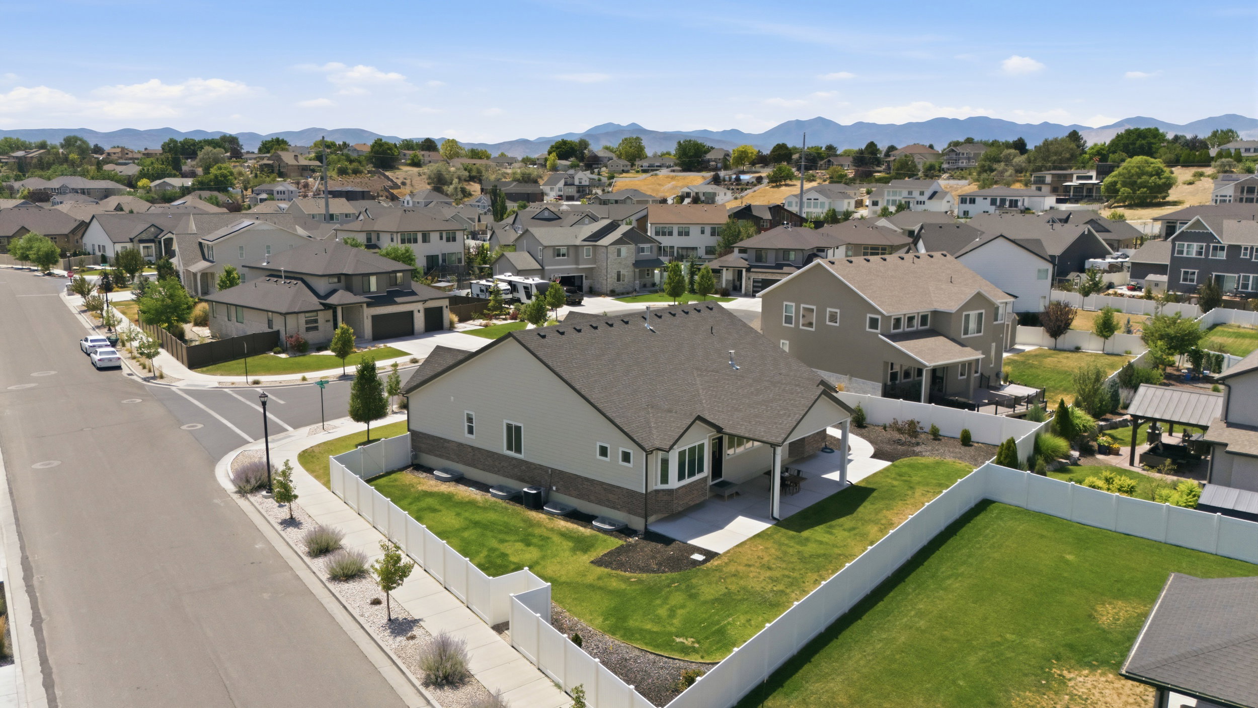 Expansive backyard featuring a manicured lawn, a covered patio, and a privacy fence