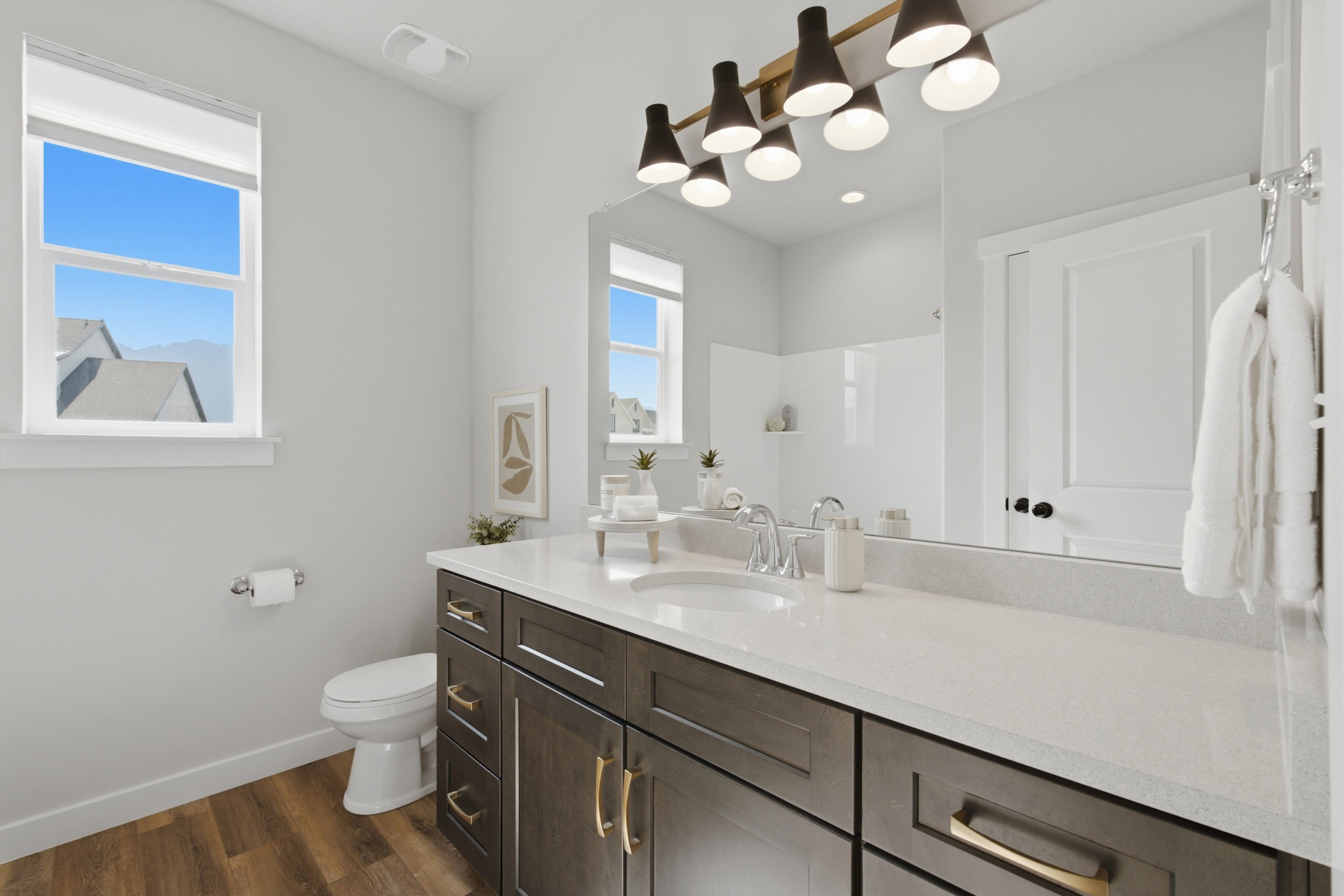 Bathroom featuring a dual-sink vanity with a light-toned countertop and dark wood-finish cabinetry