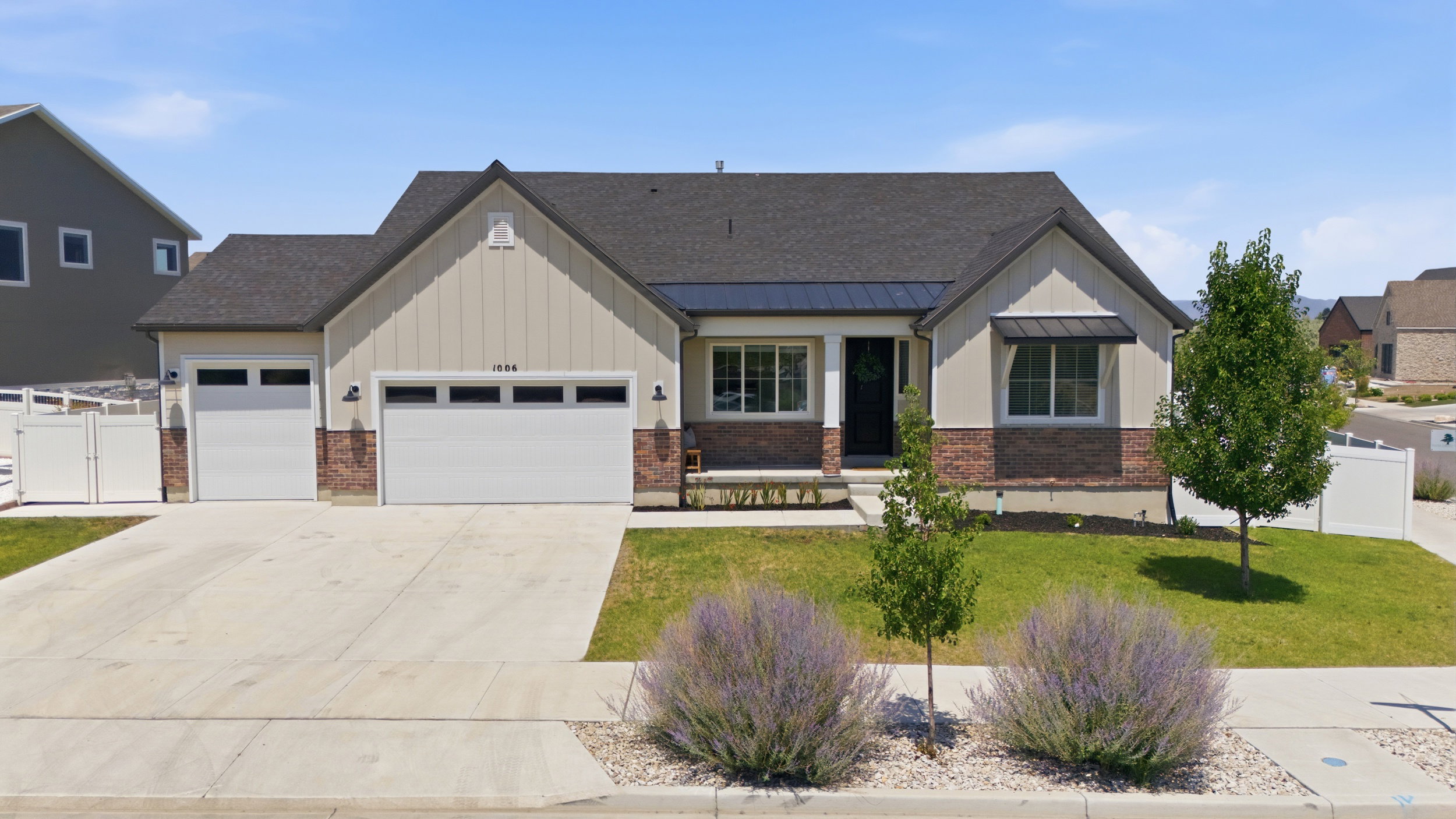 Contemporary ranch-style exterior featuring a dark asphalt shingle roof, brick and vertical siding accents, and a covered entry