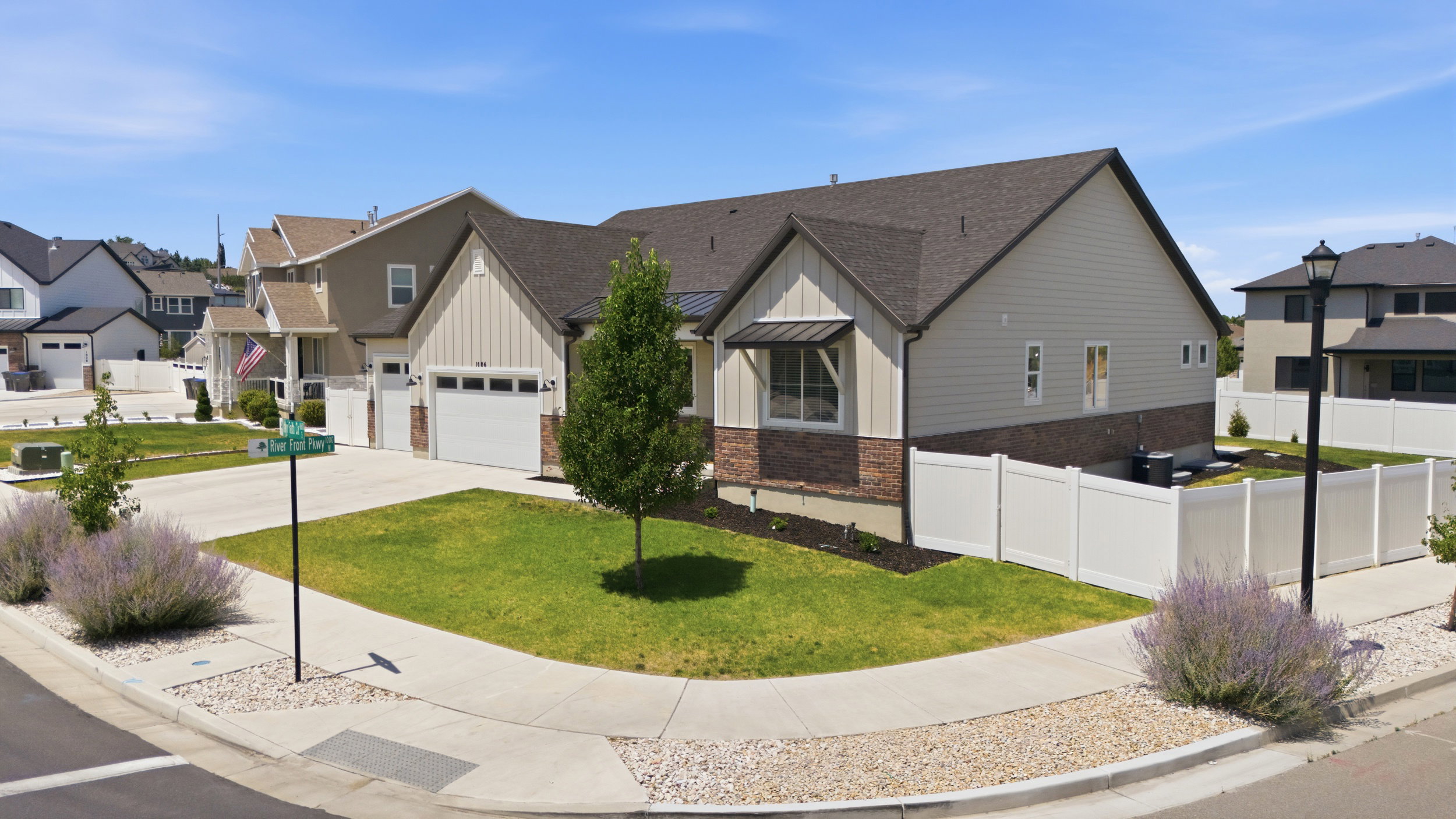 Corner lot residence featuring a two-car garage, partial brick and siding exterior, and a fully fenced rear yard