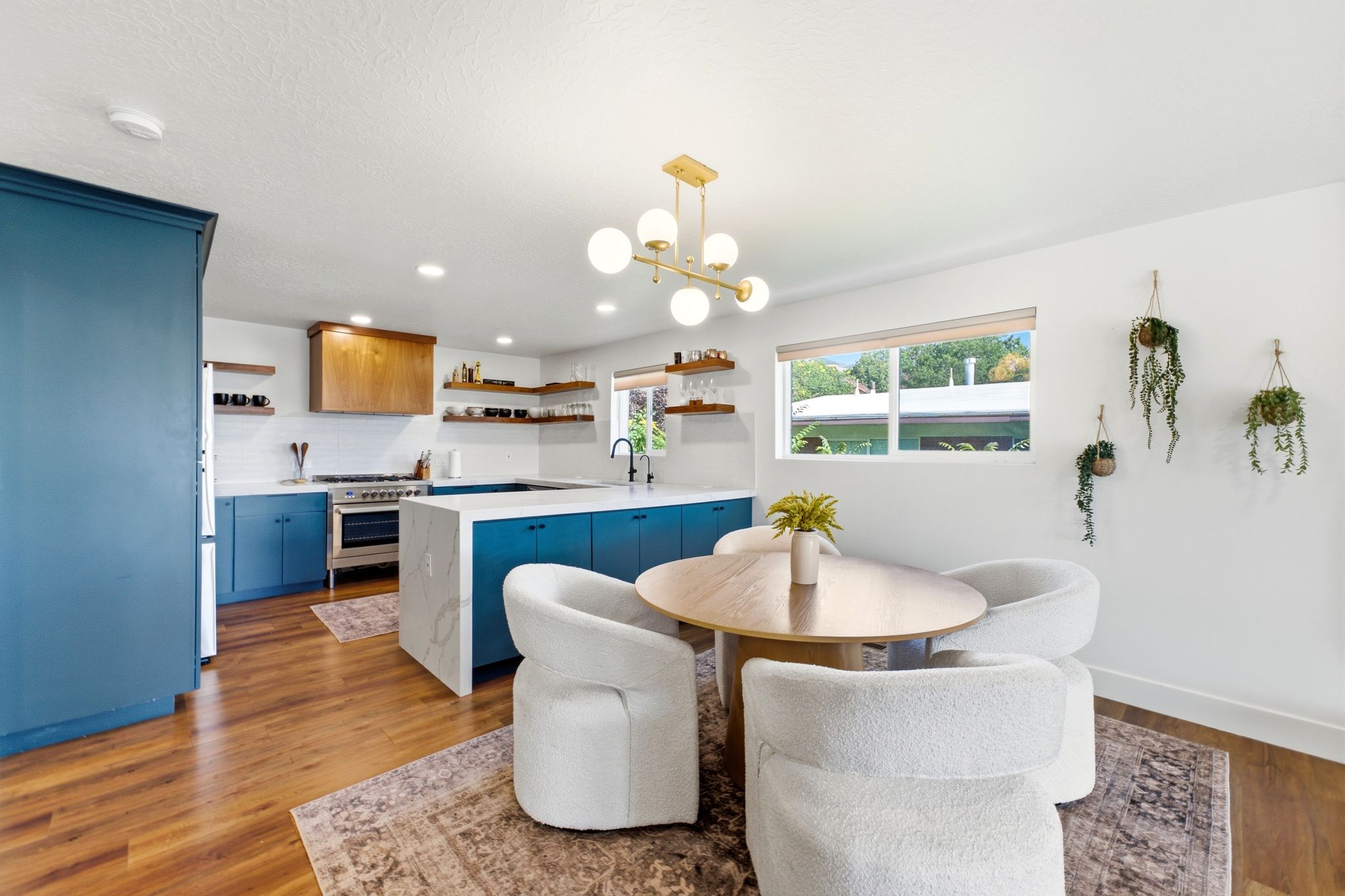 Open-concept kitchen and dining area featuring rich wood-finish flooring