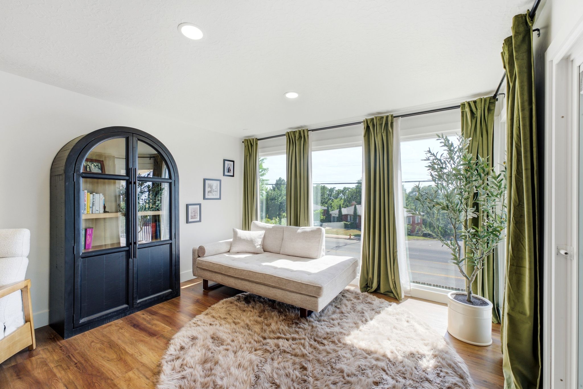 Bright interior featuring wood-finish flooring, recessed lighting, and large windows with privacy drapery