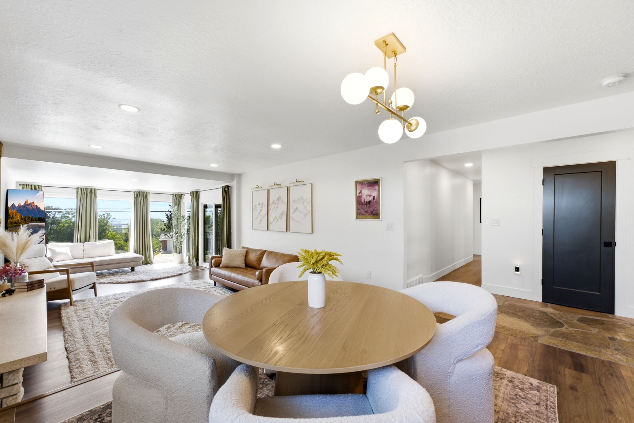 Open-concept interior featuring wood-finish flooring, recessed lighting, and a contemporary brass chandelier