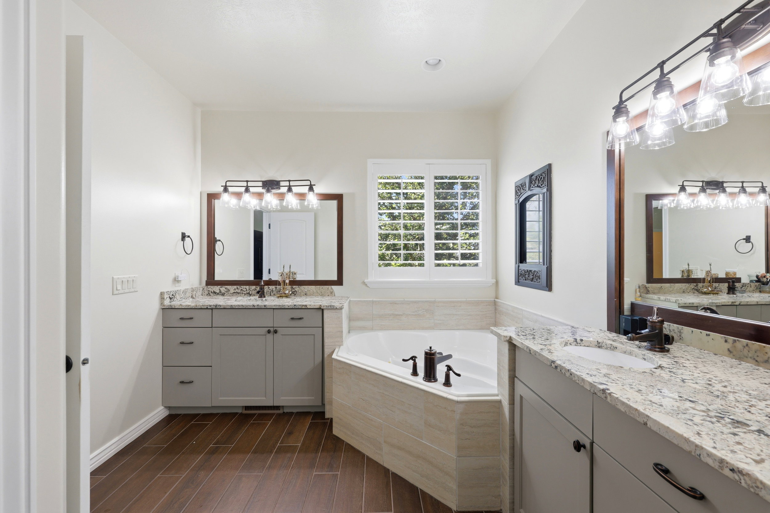 Dual vanity with granite-style countertops and gray cabinetry