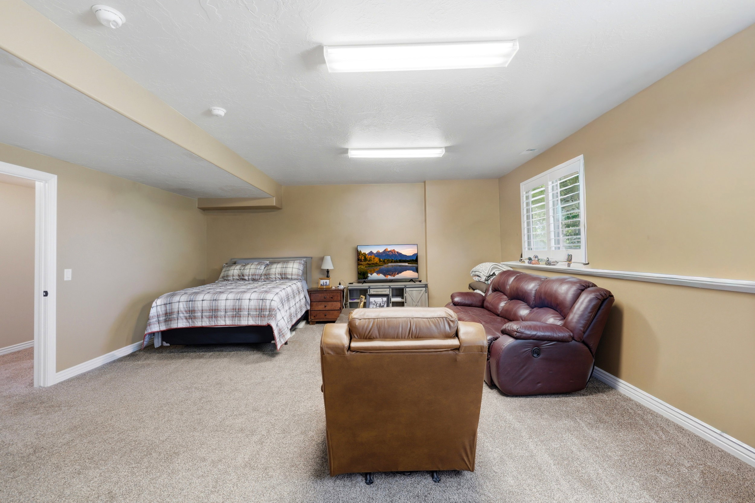 Lower-level room with neutral carpeting and warm beige walls