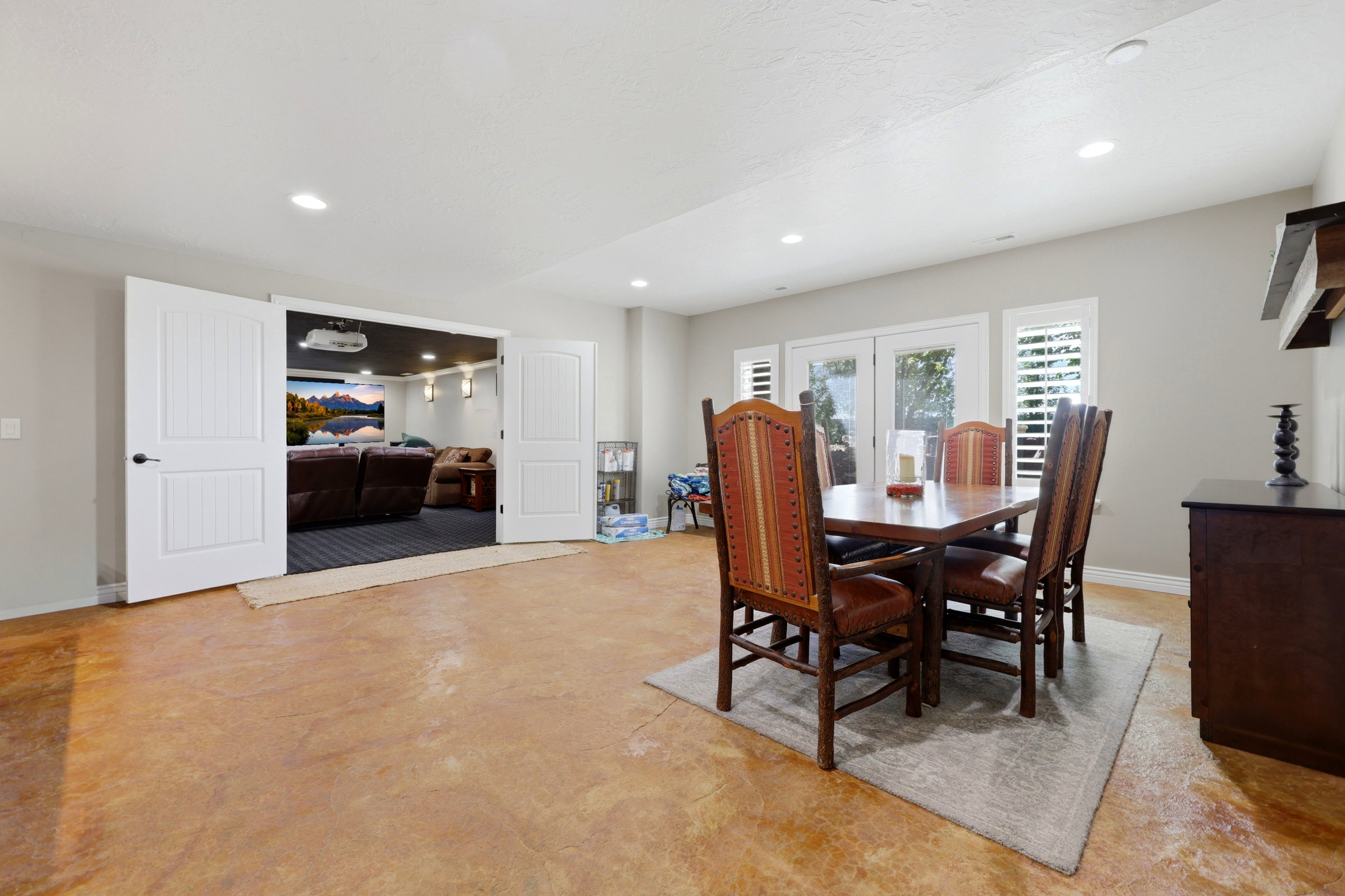 Spacious room featuring concrete-finish flooring, recessed lighting, and light gray wall paint