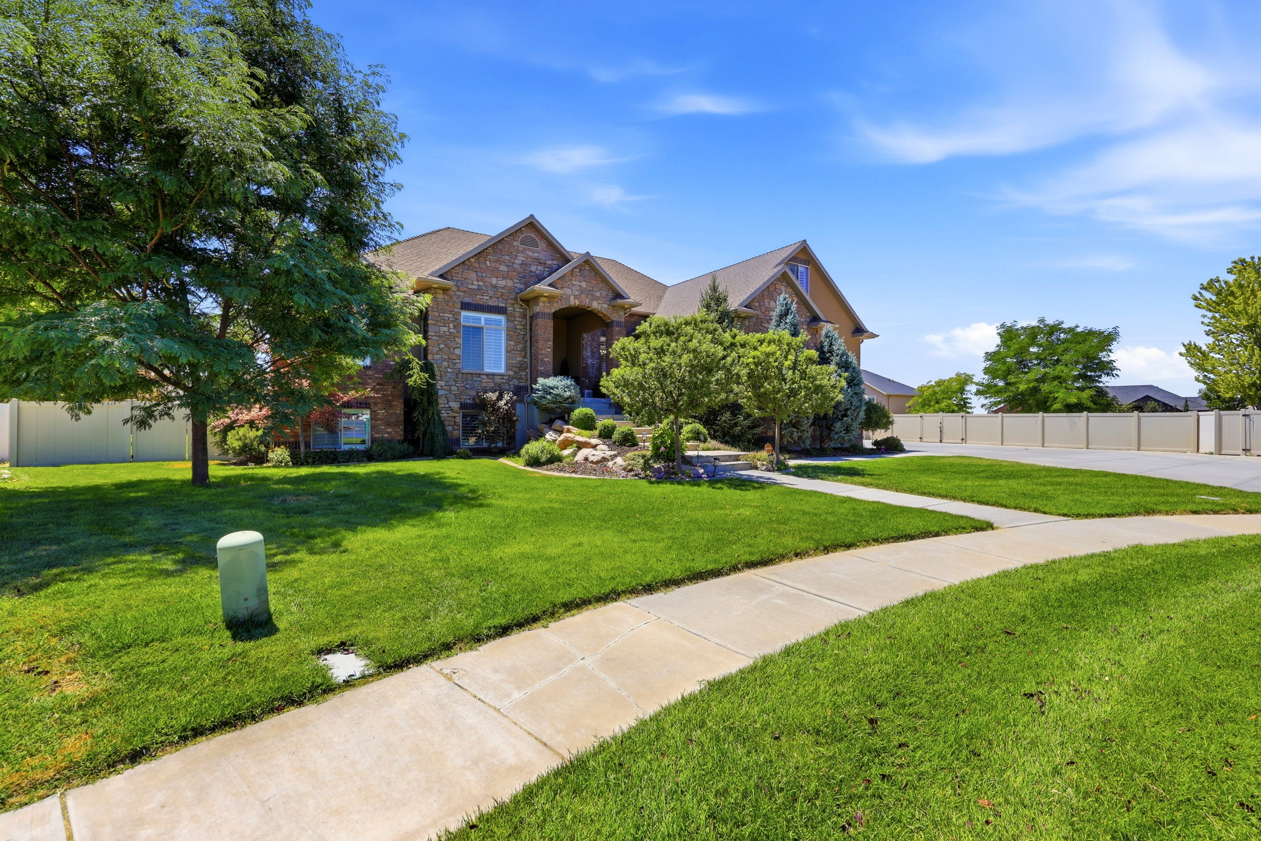 Stately brick and stone facade residence featuring an arched entryway and gabled roofline