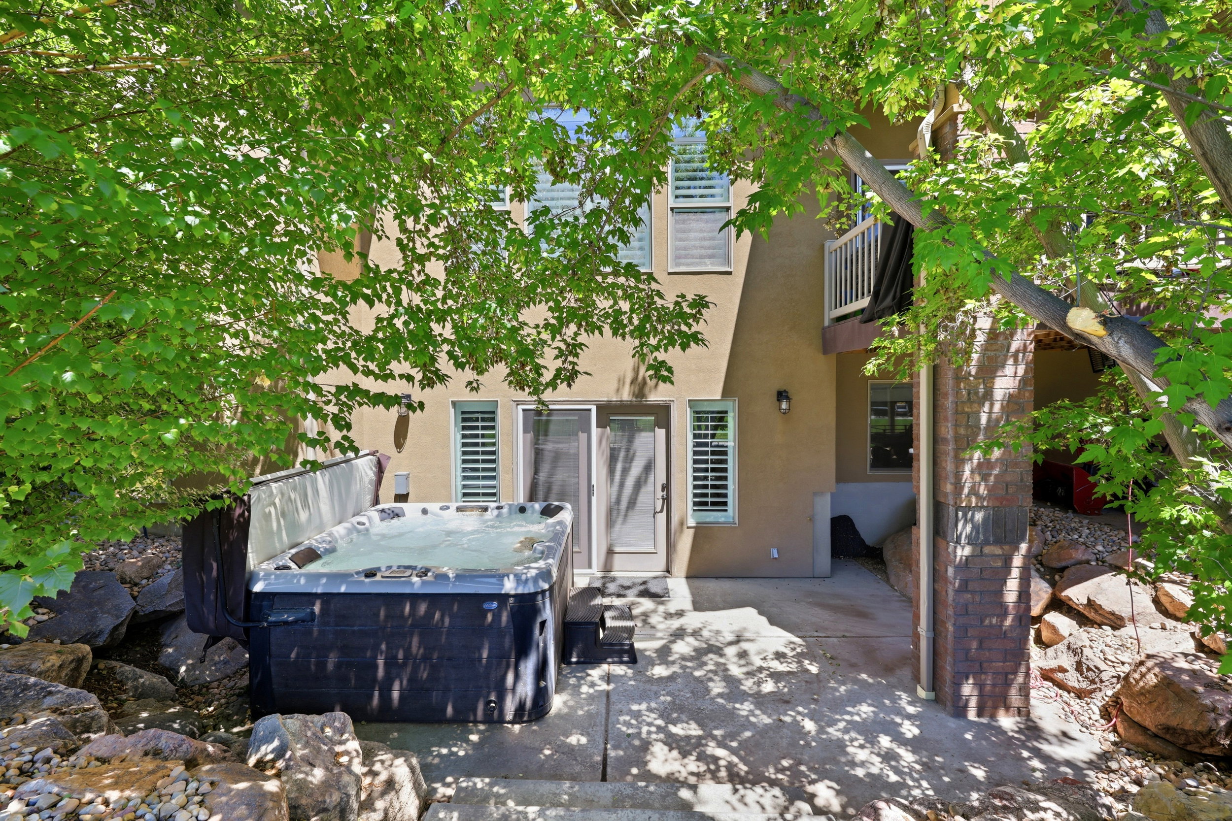 Patio area featuring a built-in spa with surrounding rock landscaping