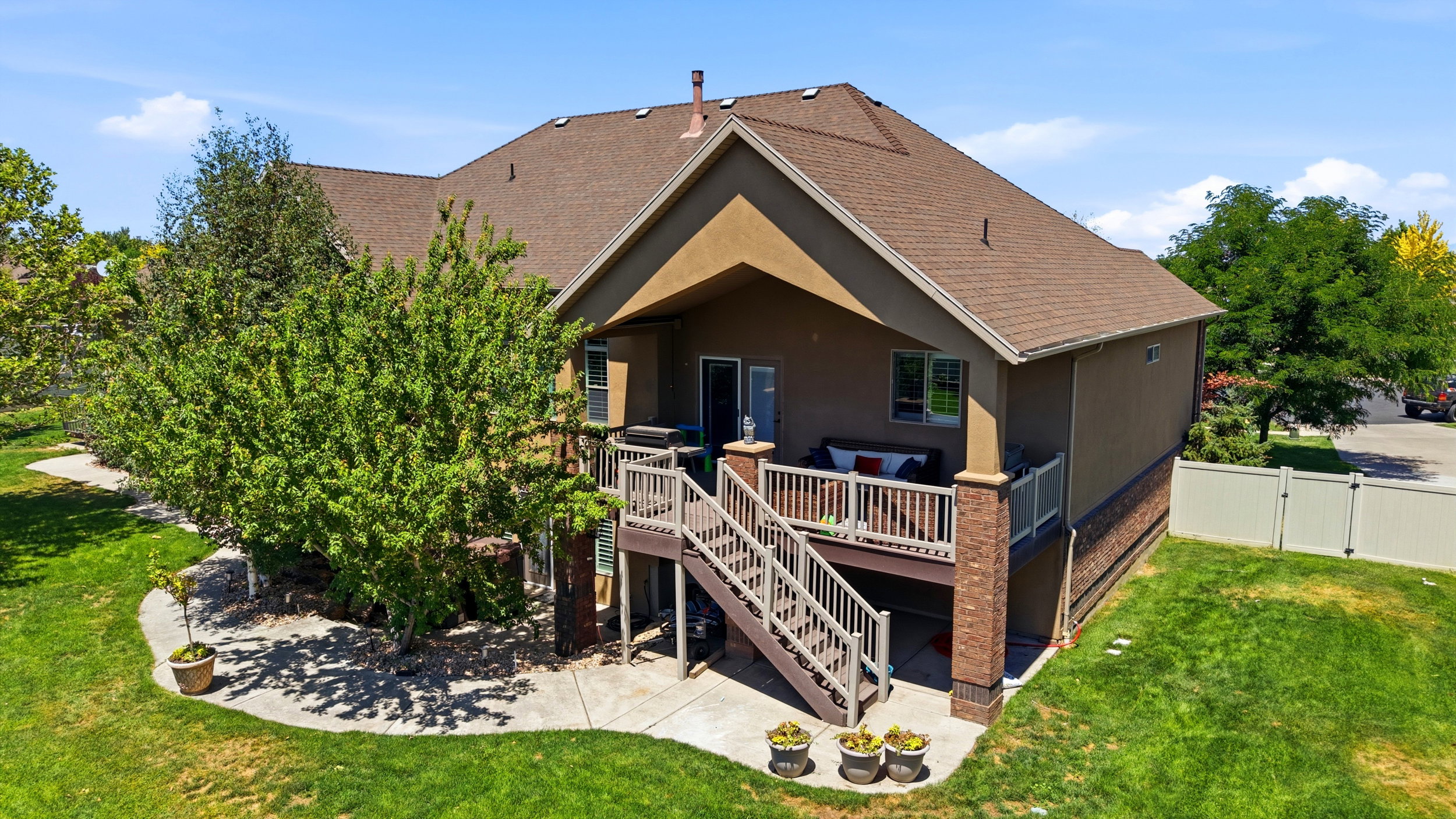 Rear exterior featuring a multi-level deck, stucco siding, and a brown shingle roof