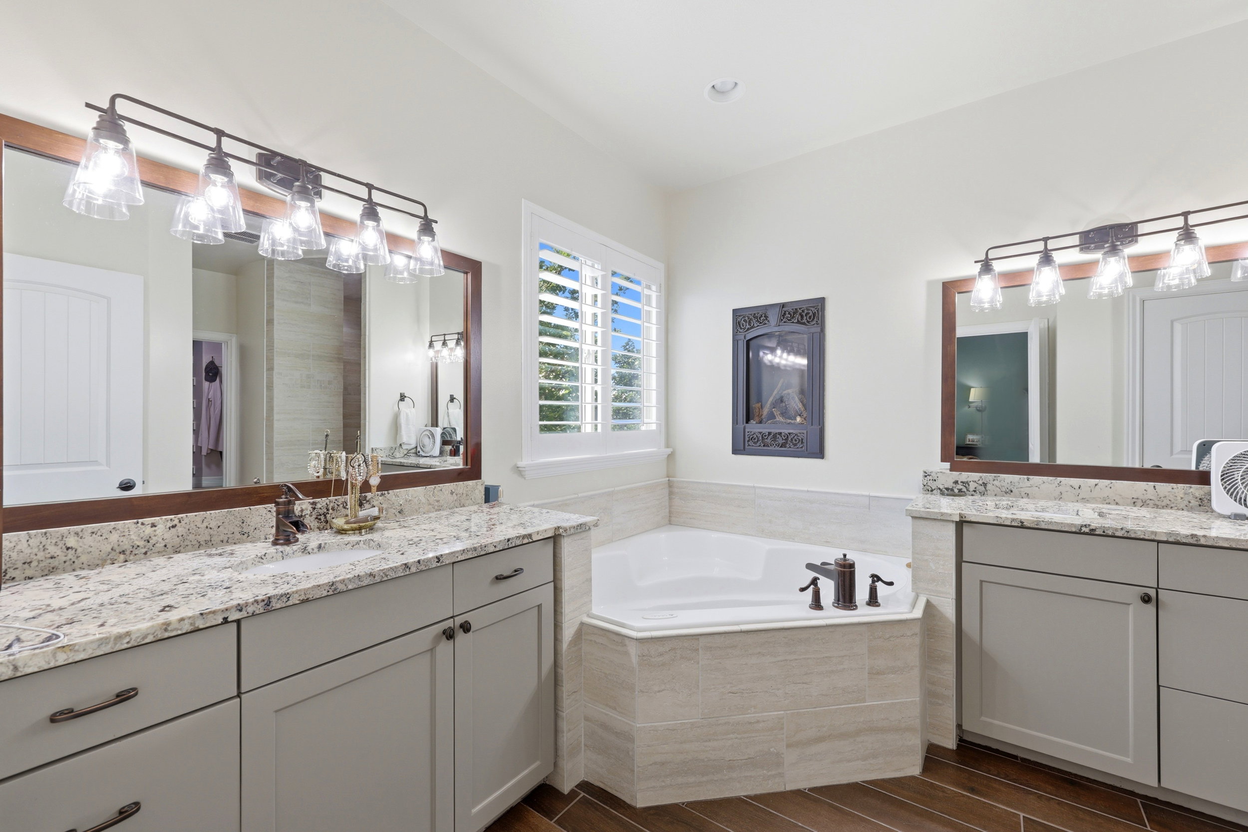 Dual vanity with granite countertops, light gray cabinetry, and dark bronze hardware