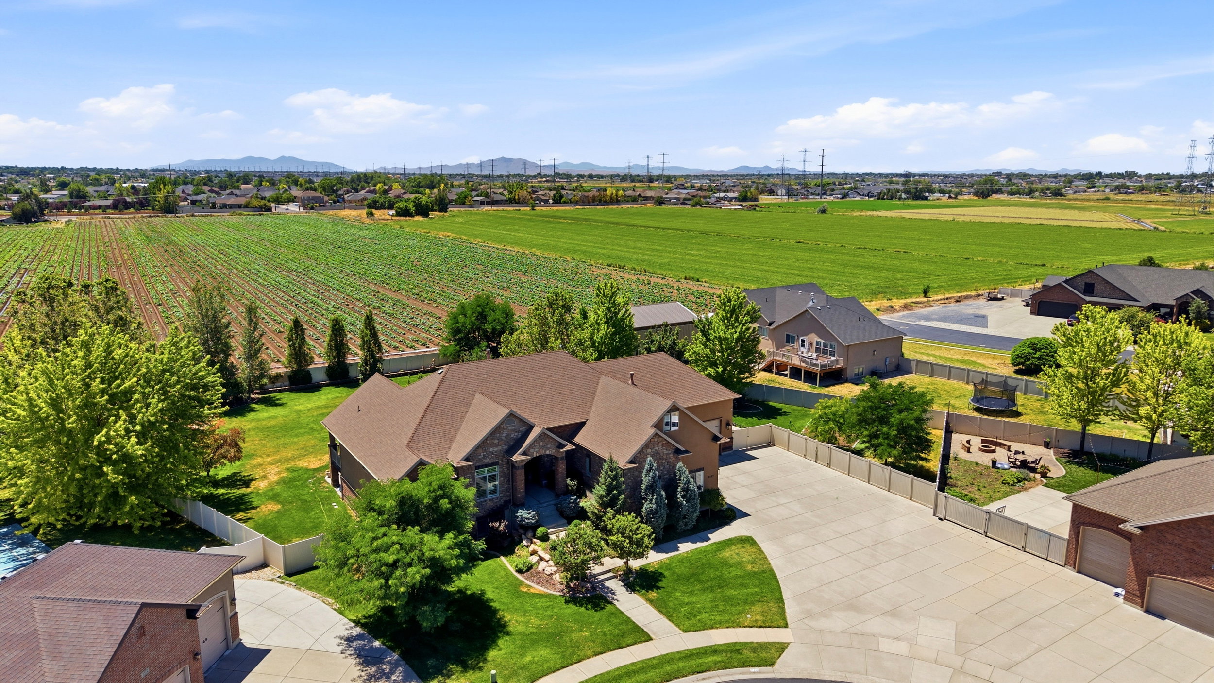 Expansive property featuring a large residence with a multi-gabled roof, brick and stone facade, and a substantial paved driveway