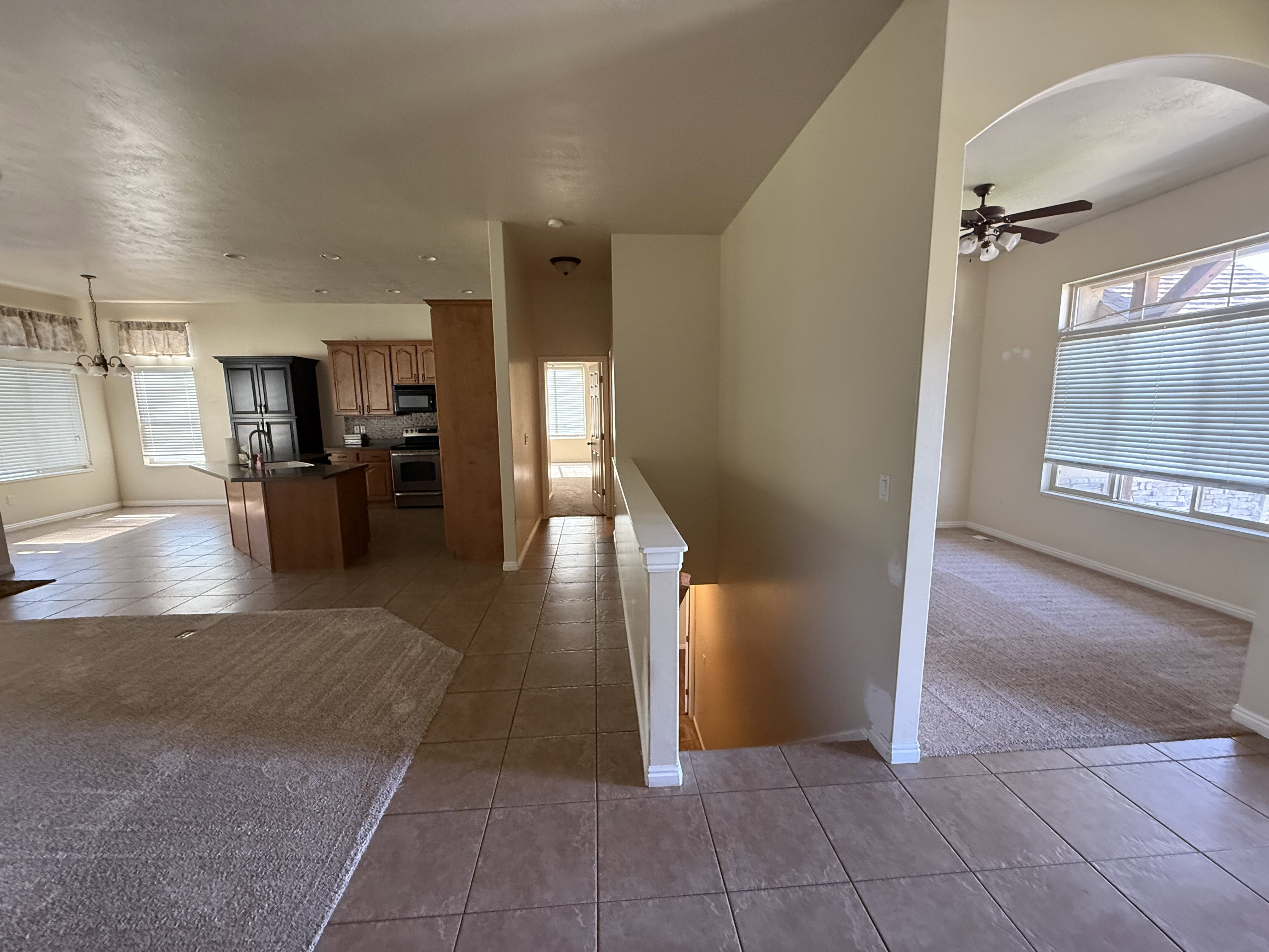 Open-concept living space with tile and carpet flooring