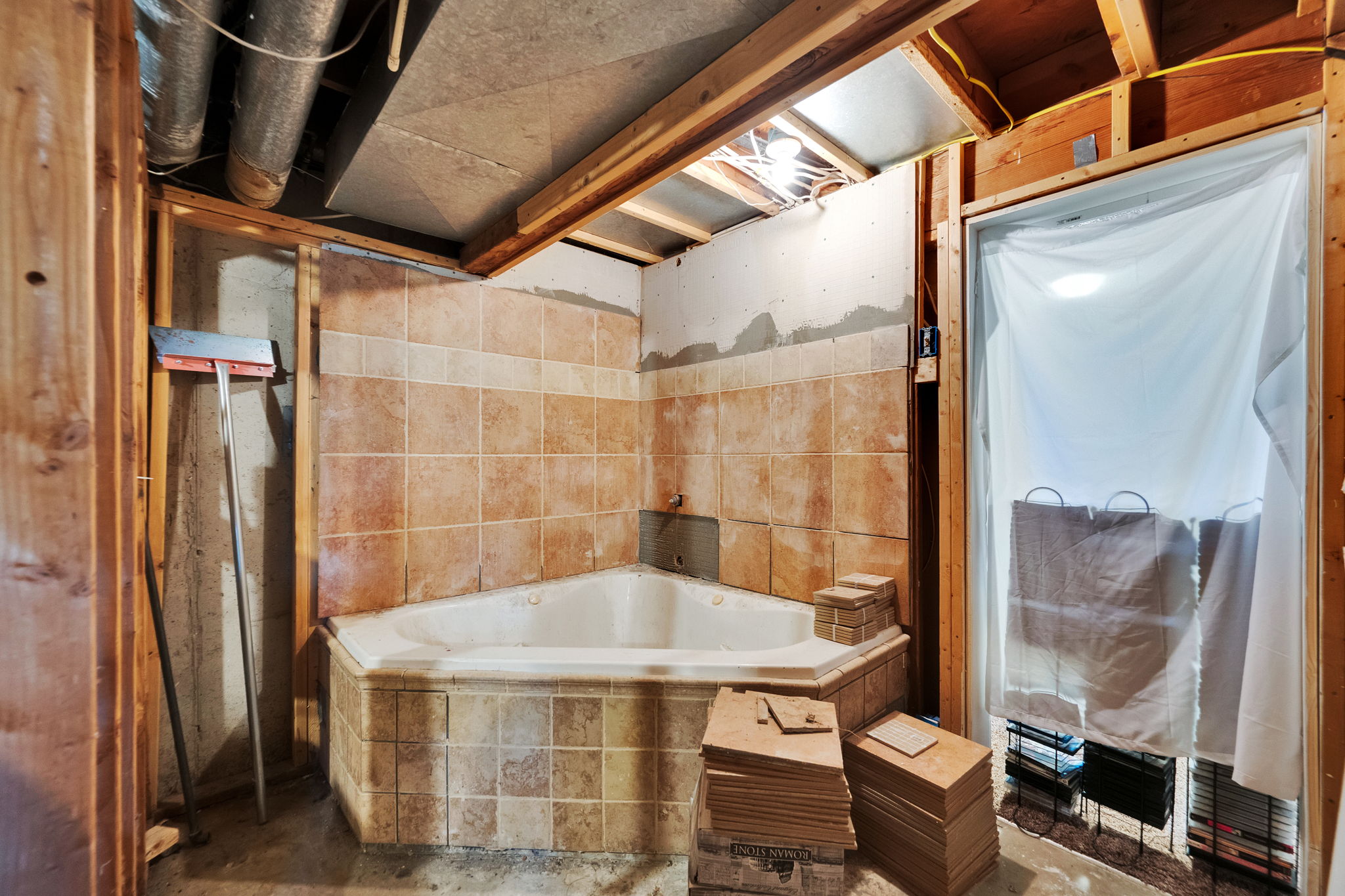 Corner soaking tub with tiled surround and wall accents