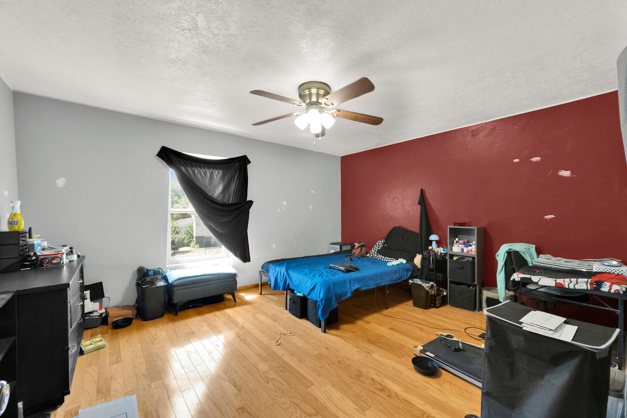 Room featuring wood-finish flooring, a vaulted ceiling, and a ceiling fan with integrated lighting
