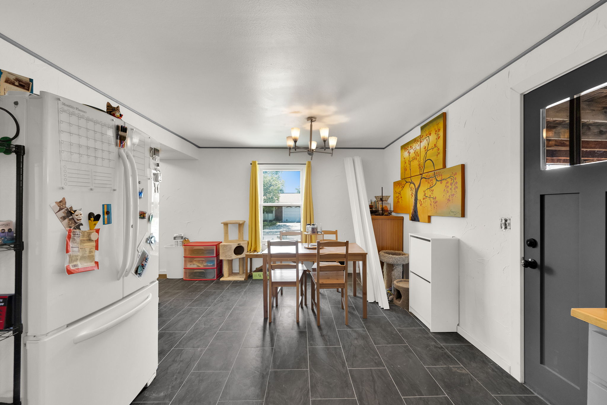 Spacious kitchen and dining area with dark rectangular tile flooring