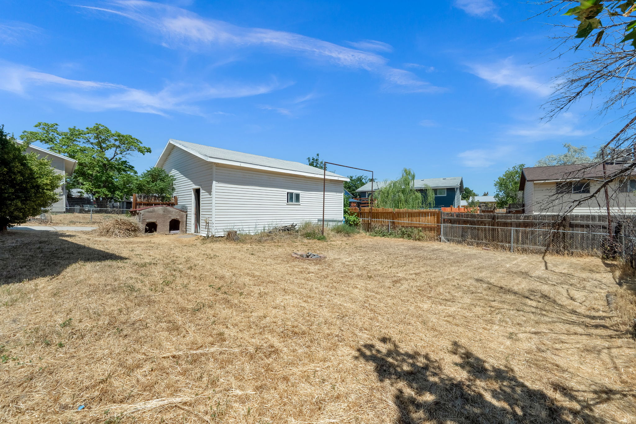 Spacious backyard with a detached storage building featuring white siding and a sloped roof