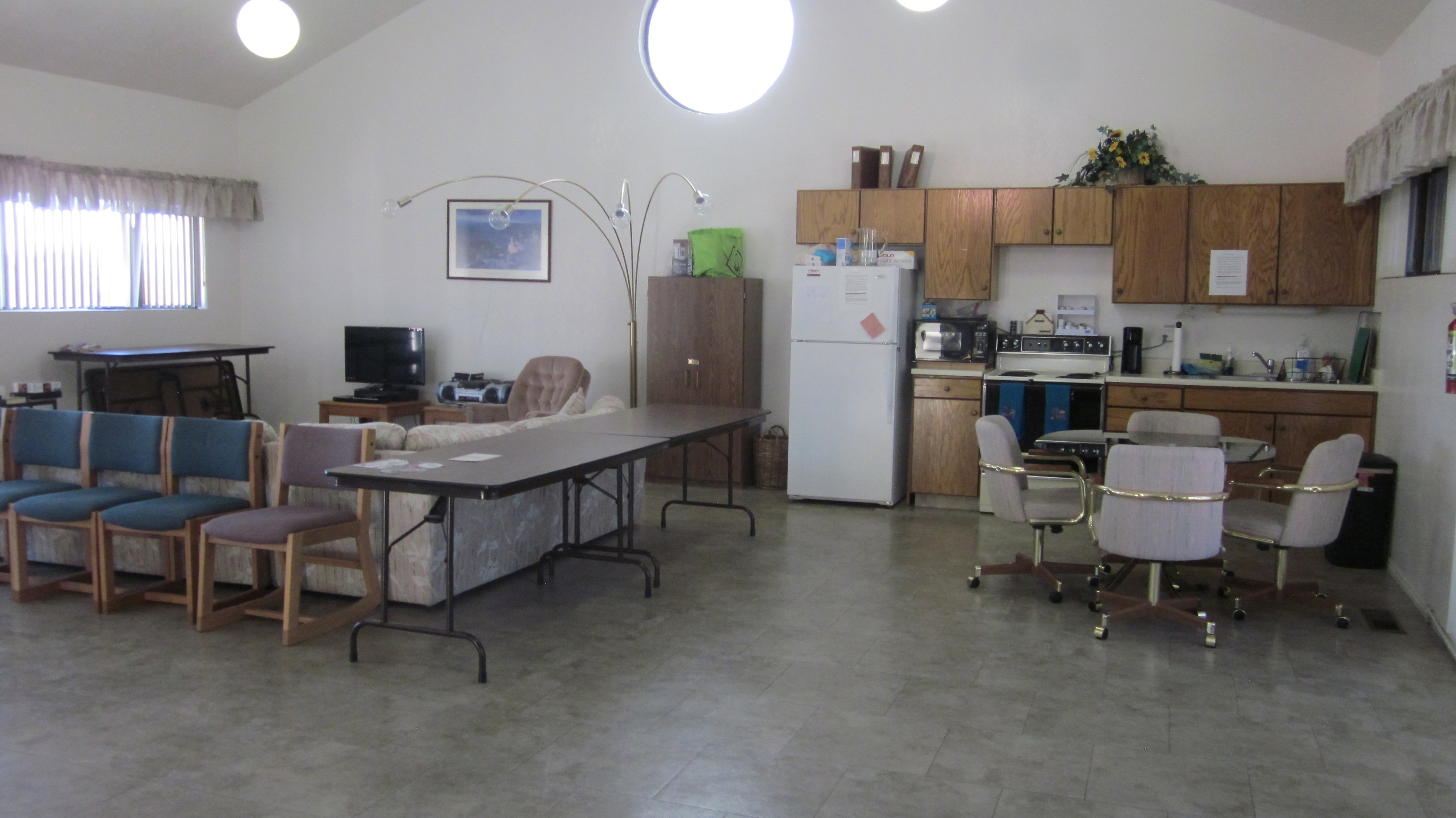 Spacious common area featuring an integrated kitchen, vaulted ceilings, recessed lighting, and ample natural light from multiple windows