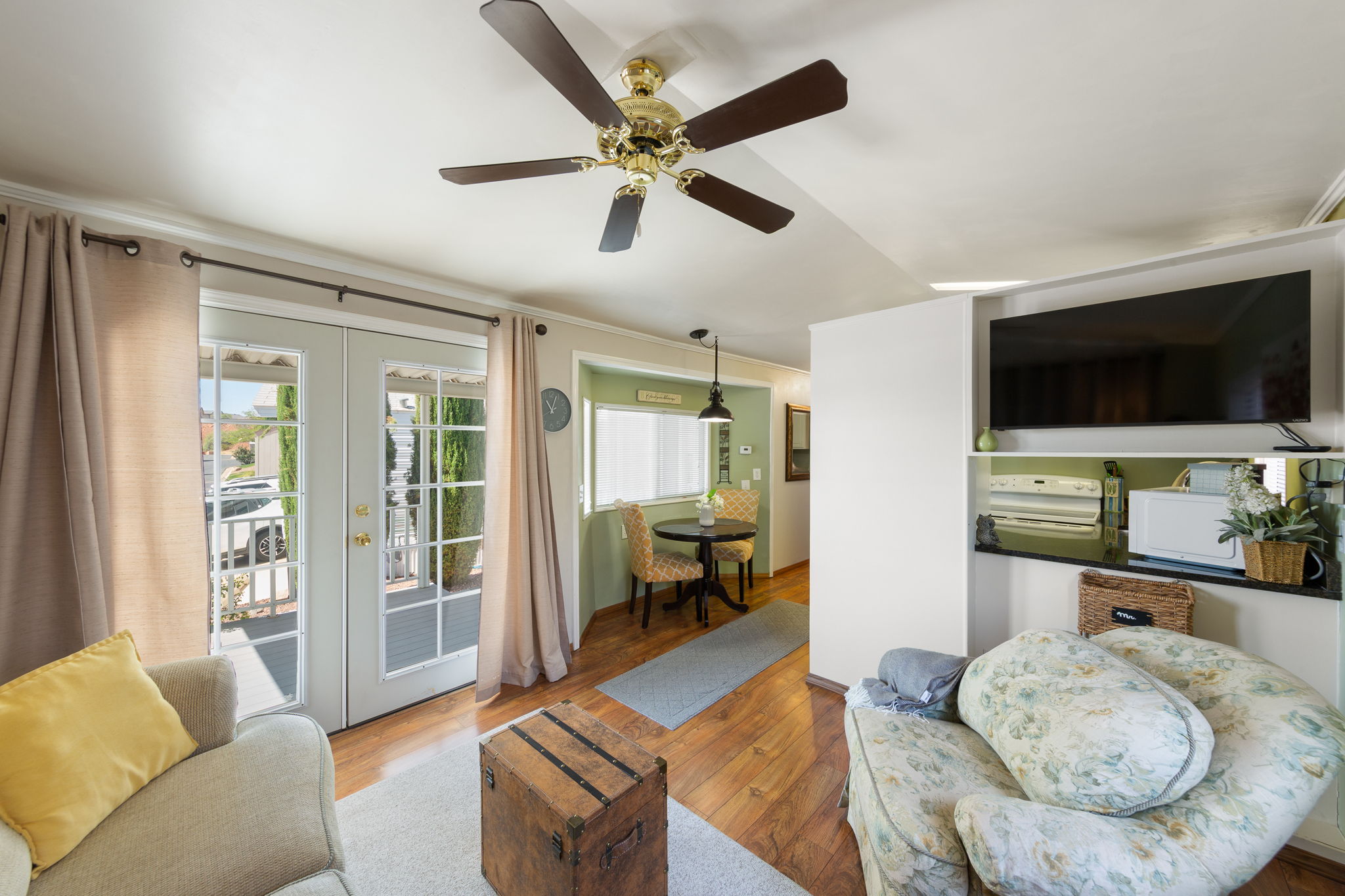 Living space featuring light wood-finish flooring, a ceiling fan, and white walls