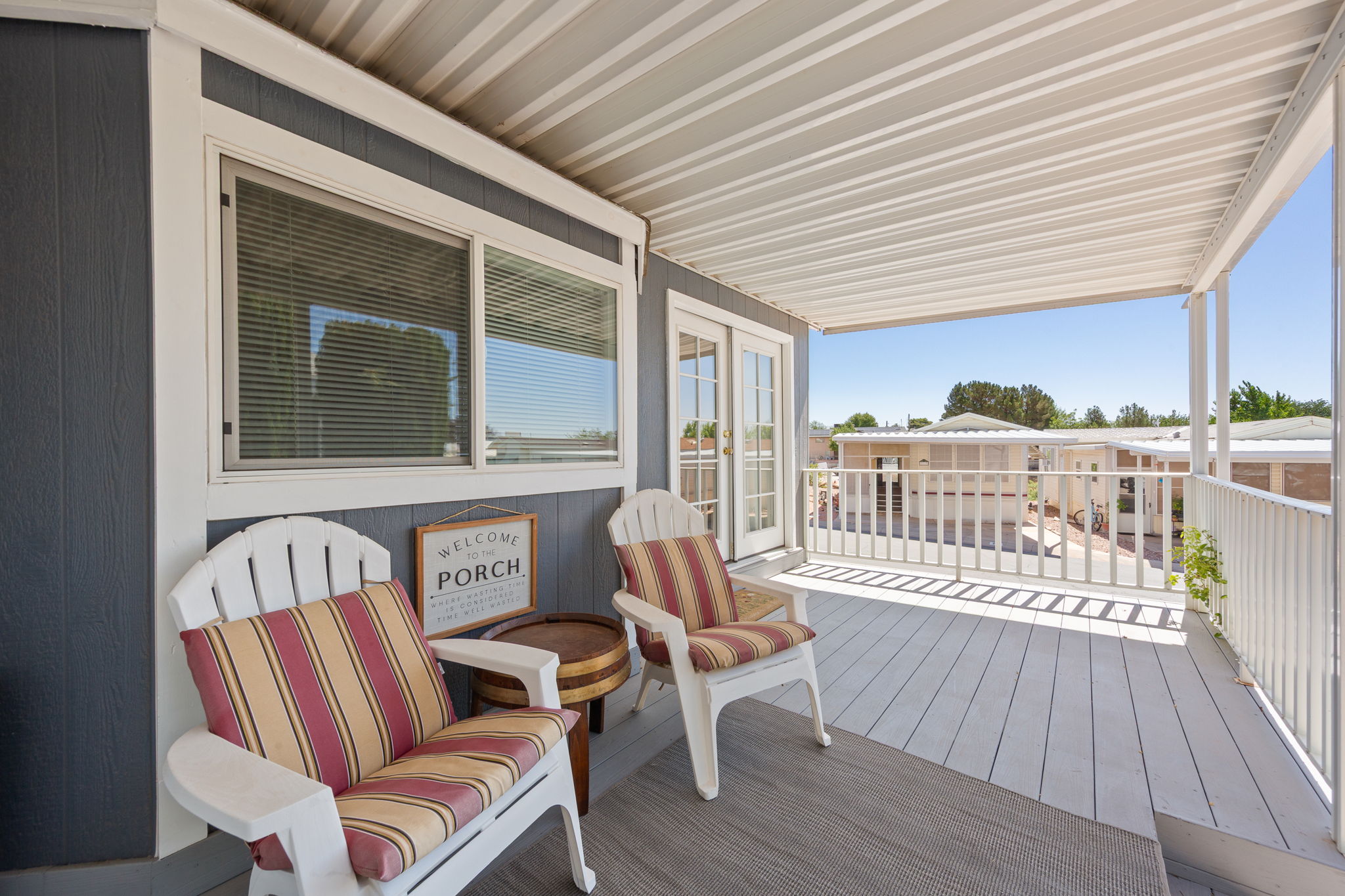 Covered exterior porch featuring a durable composite deck and white railing