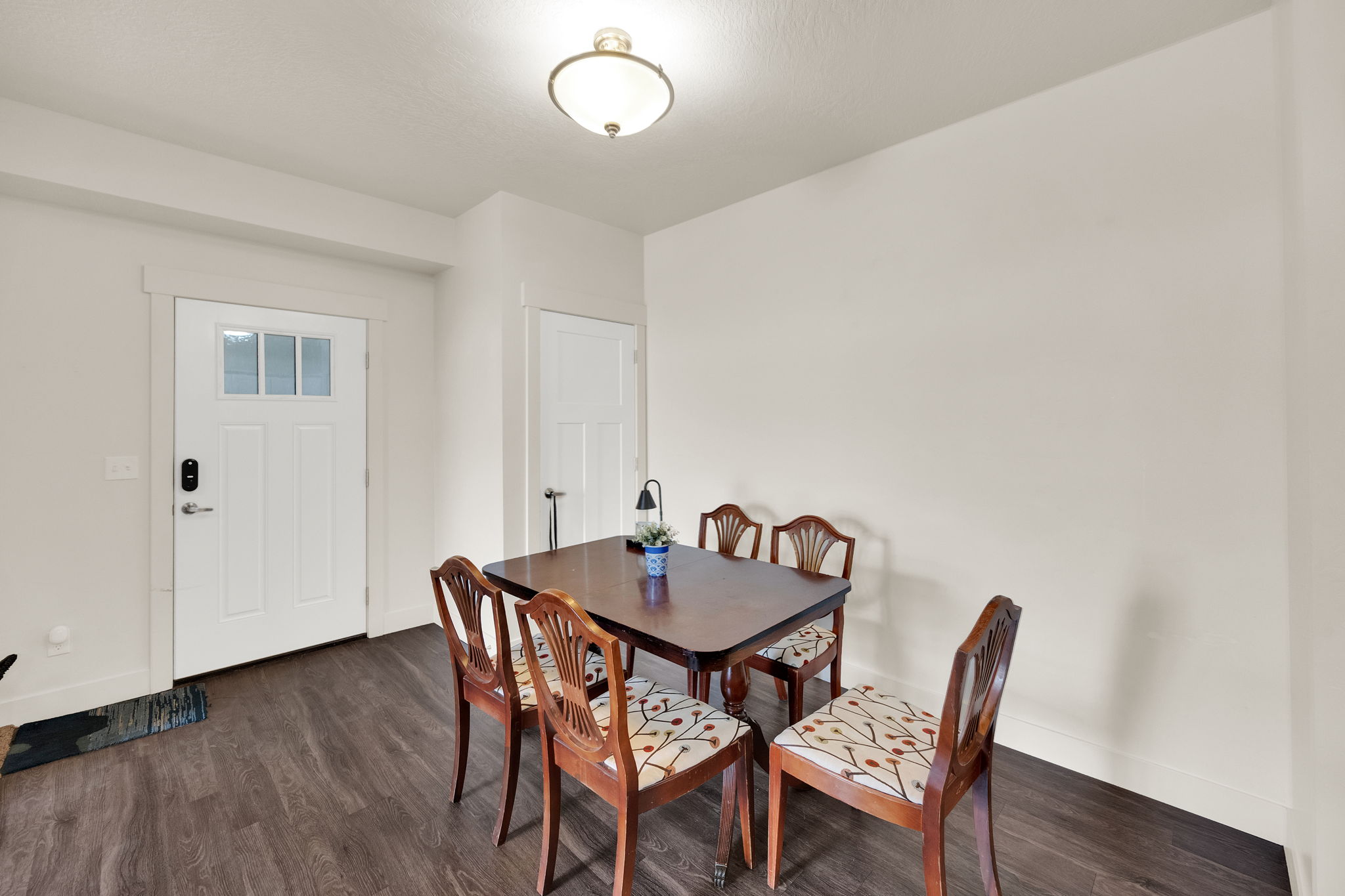 Entryway featuring wood-finish flooring, a white paneled door with frosted glass inserts, and a built-in flush mount light fixture