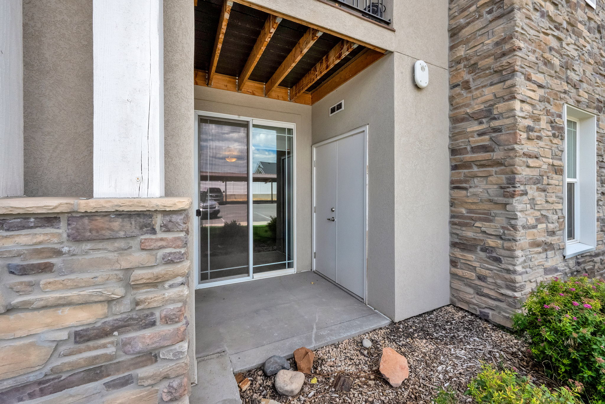 Patio entrance featuring a sliding glass door, an adjacent storage closet, and a concrete pad