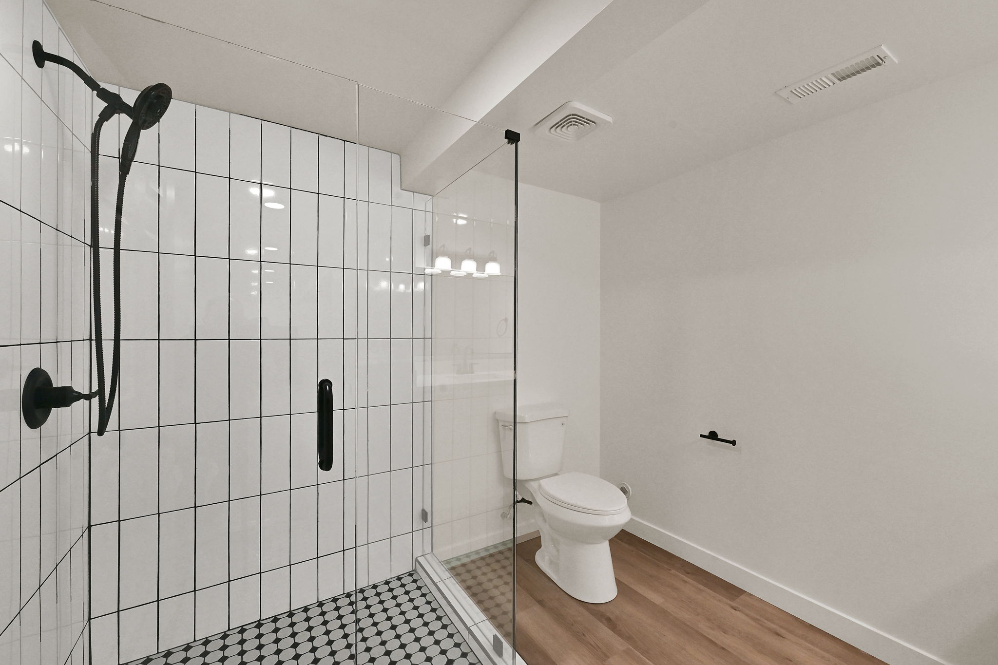 Walk-in shower with clear glass enclosure and matte black fixtures