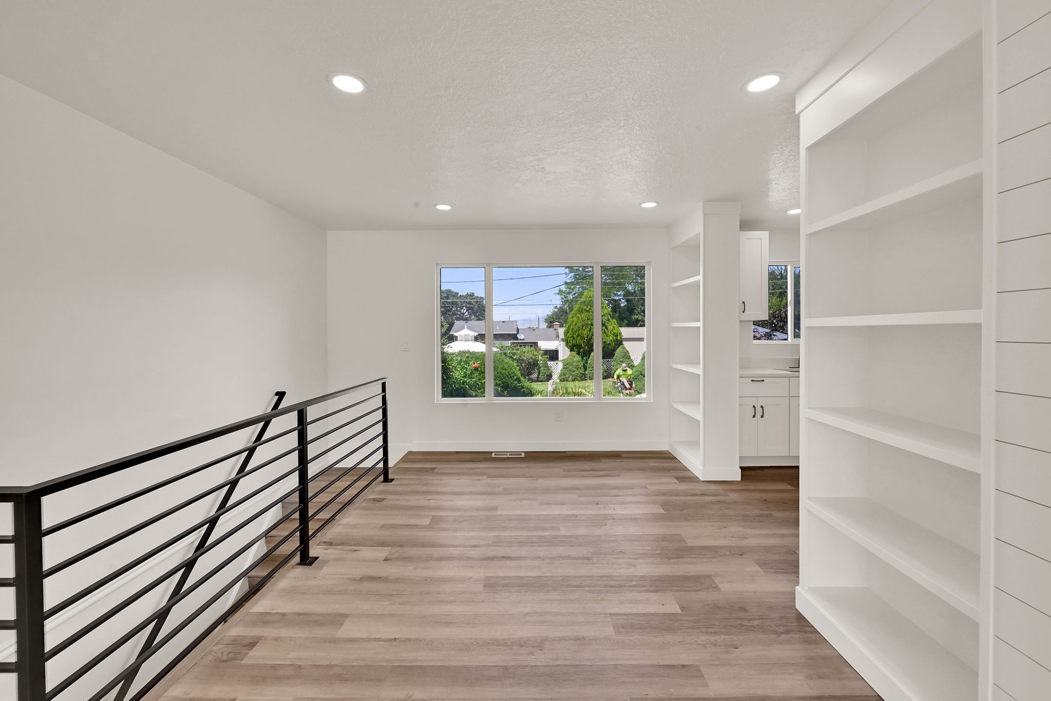 Open concept living area with wood-finish flooring and recessed lighting