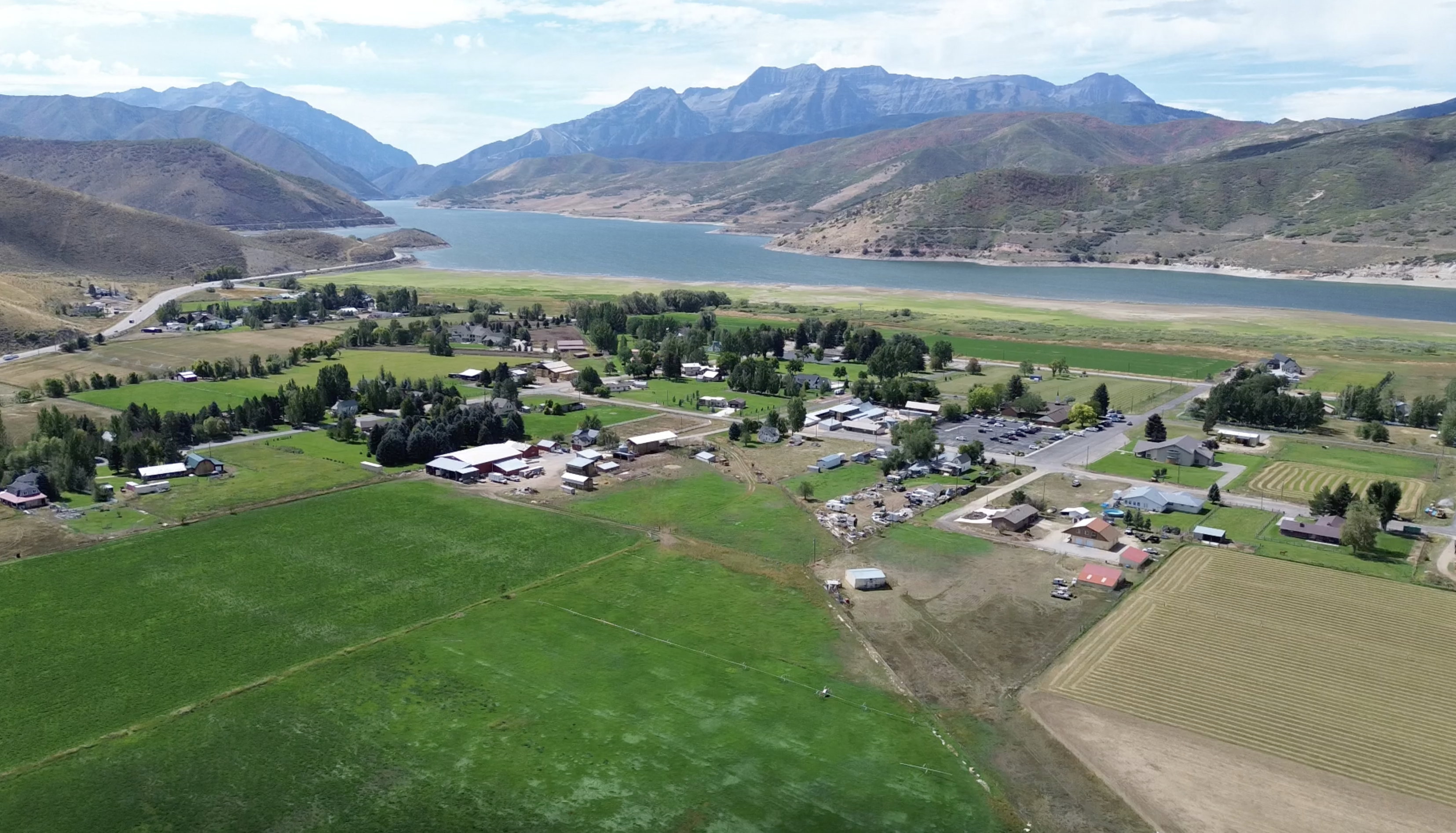 Expansive green fields bordering a community with diverse buildings and structures