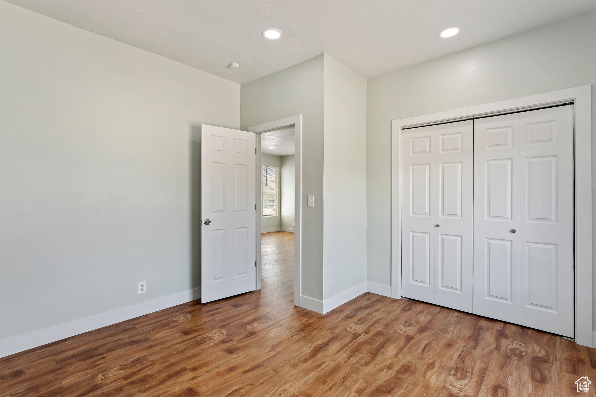 Bedroom featuring wood-finish flooring, recessed lighting, and a double bi-fold closet