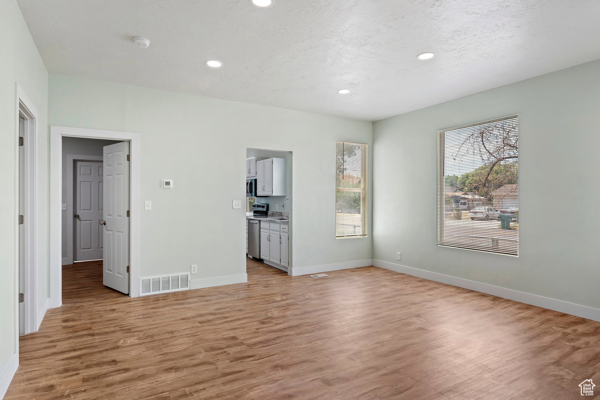 Spacious living area featuring wood-finish flooring, recessed lighting, and light-toned walls