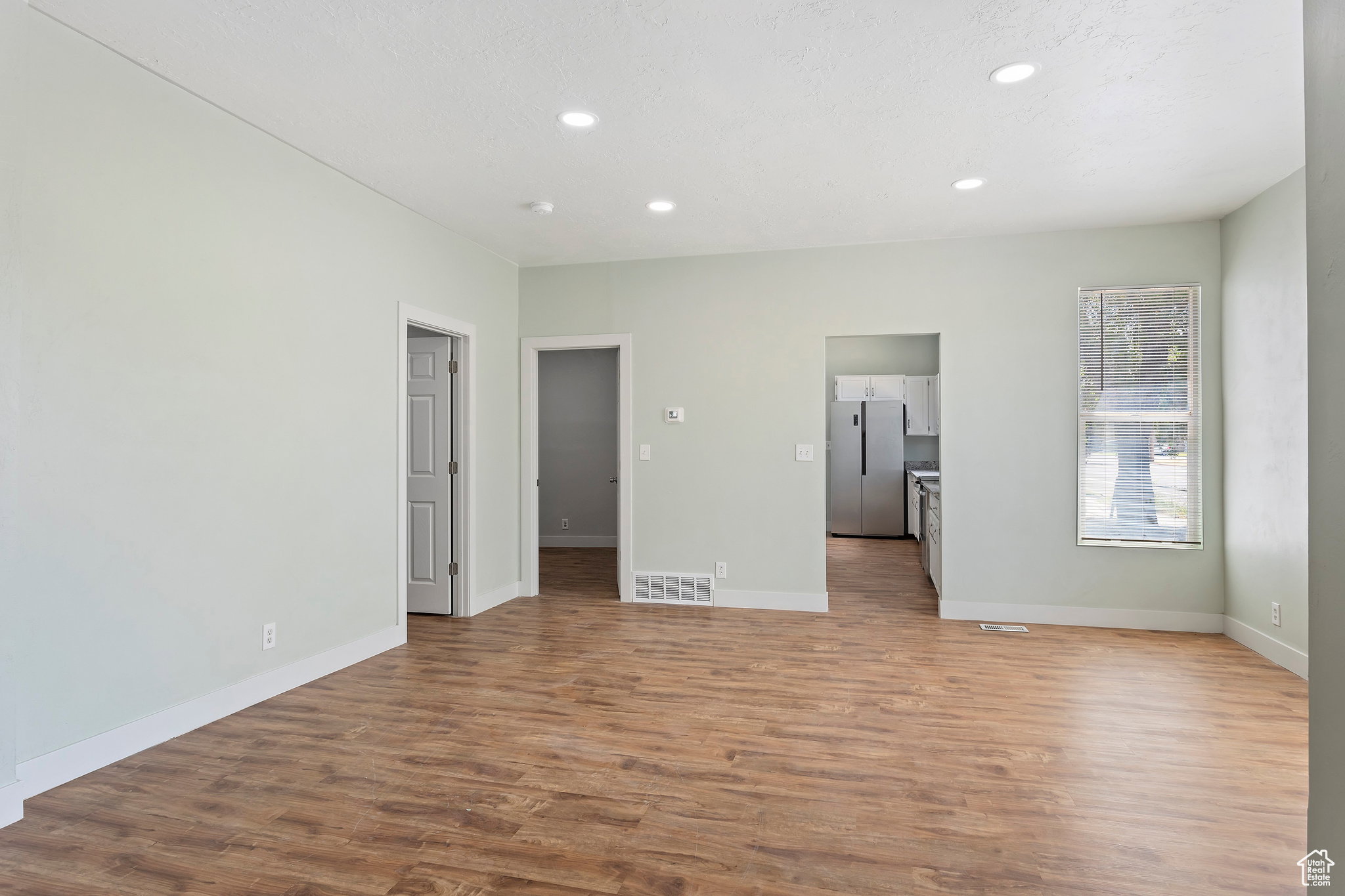 Bright interior space featuring wood-finish flooring, recessed lighting, and light-toned wall paint