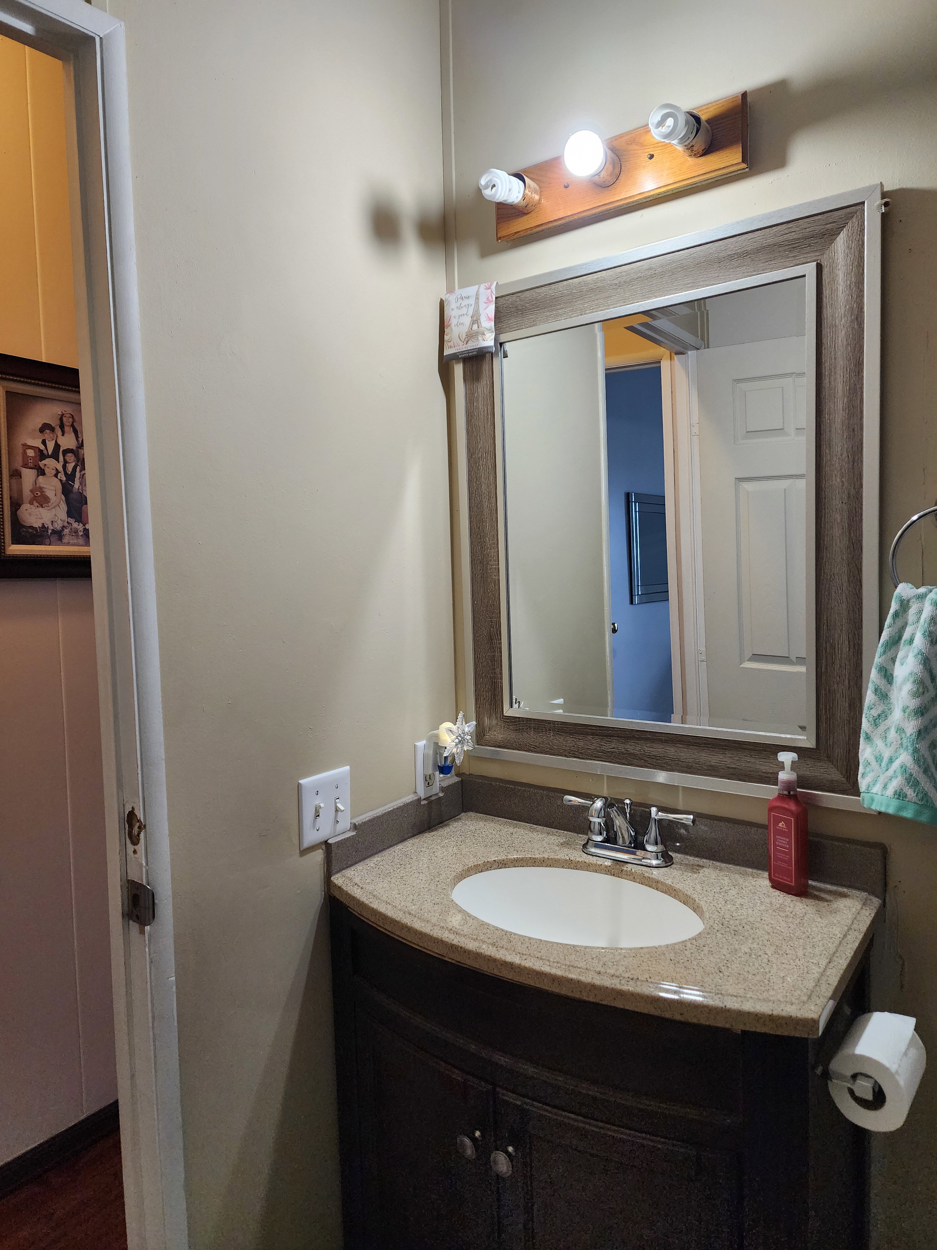 Bathroom vanity featuring an integrated oval sink, granite-style countertop, and a dark wood-finish cabinet with double doors