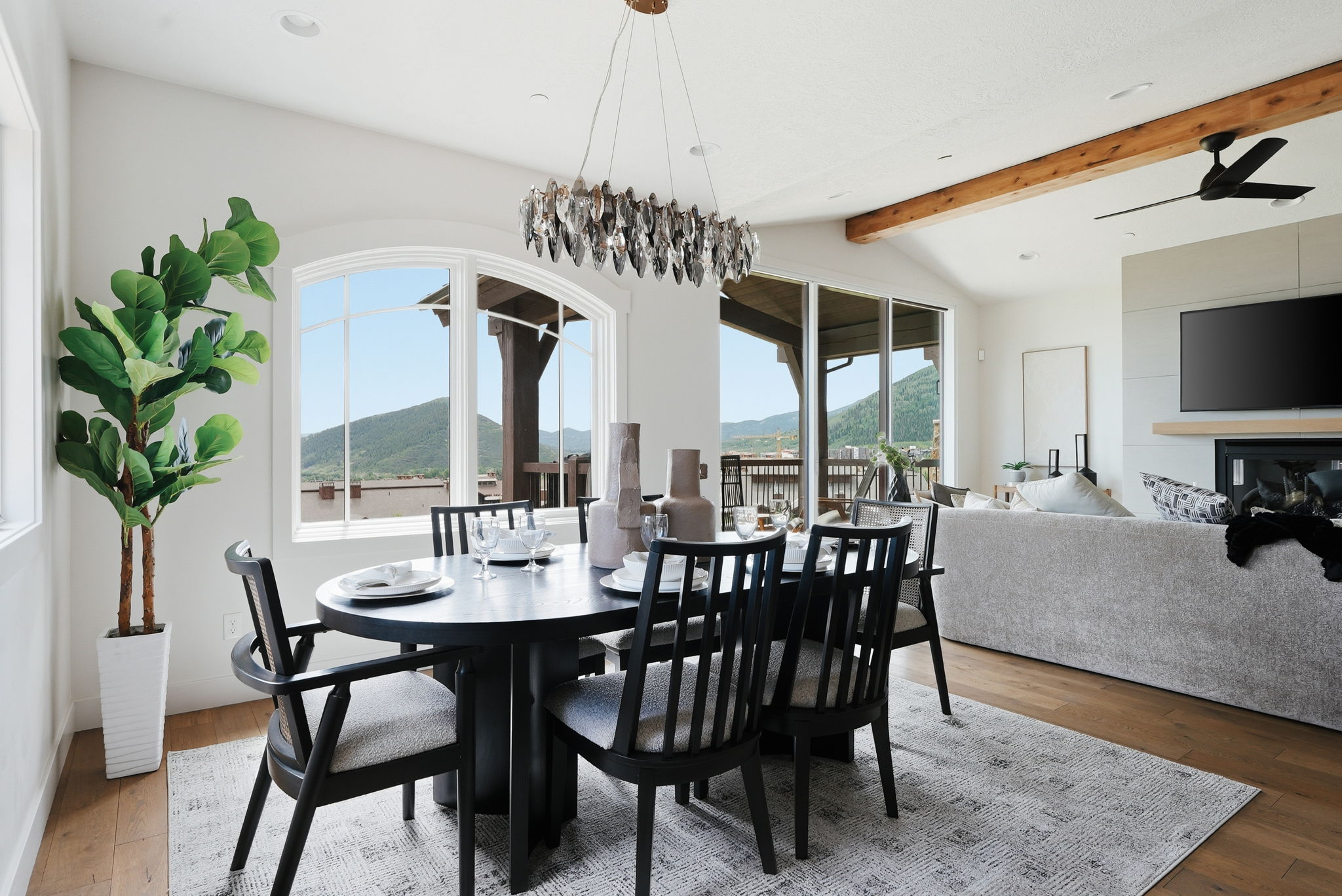 Dining area featuring a contemporary chandelier, arched window, and wood-finish flooring