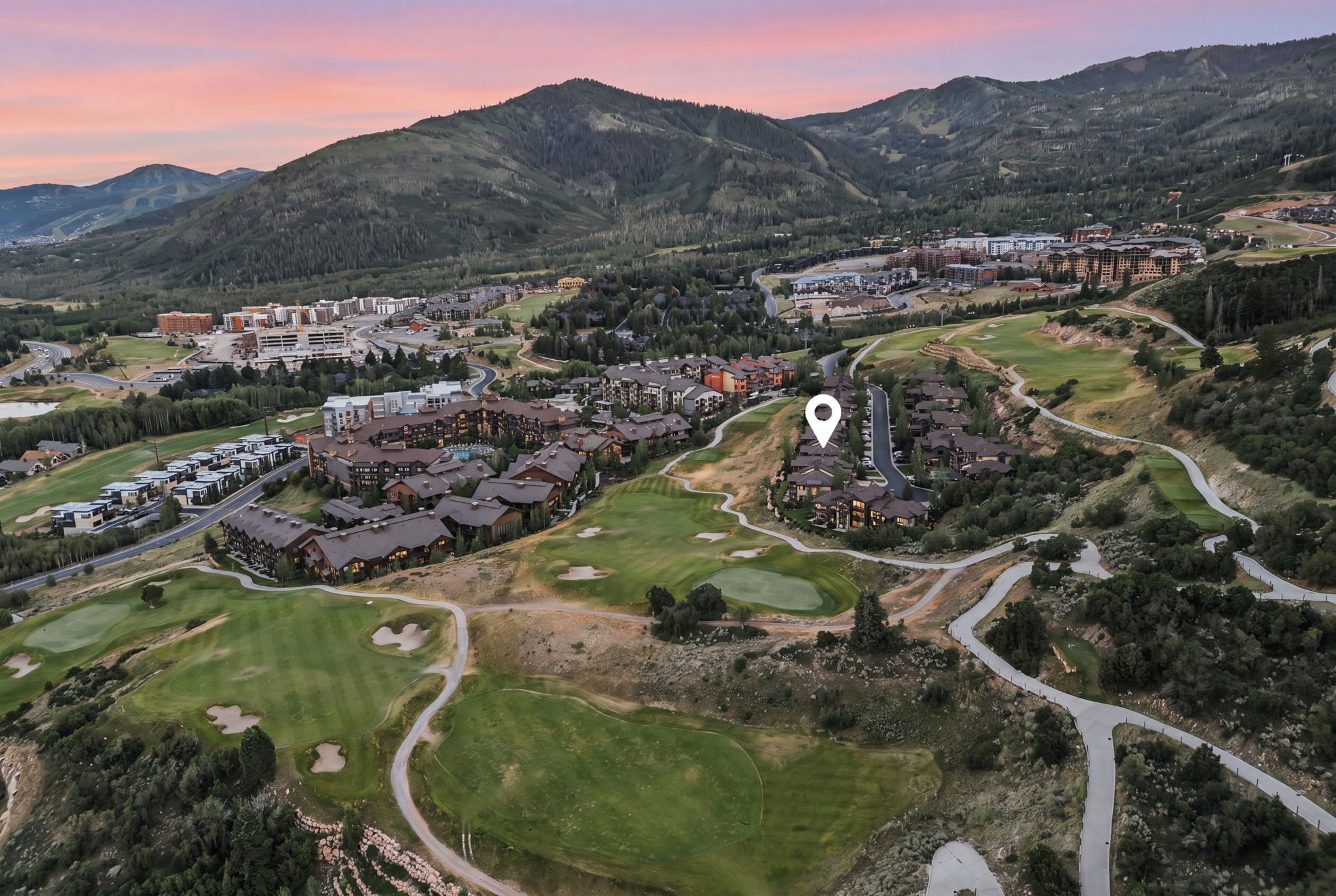 Elevated mountain community featuring multiple residential buildings and golf course terrain