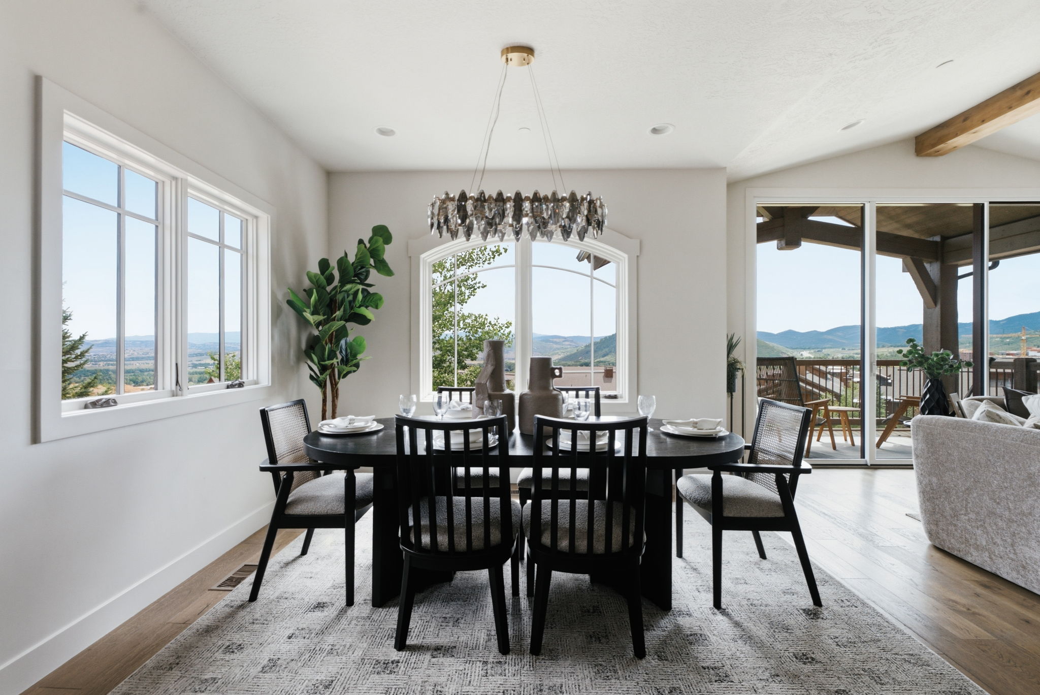 Dining area featuring large picture windows, arched window, and wood-finish flooring