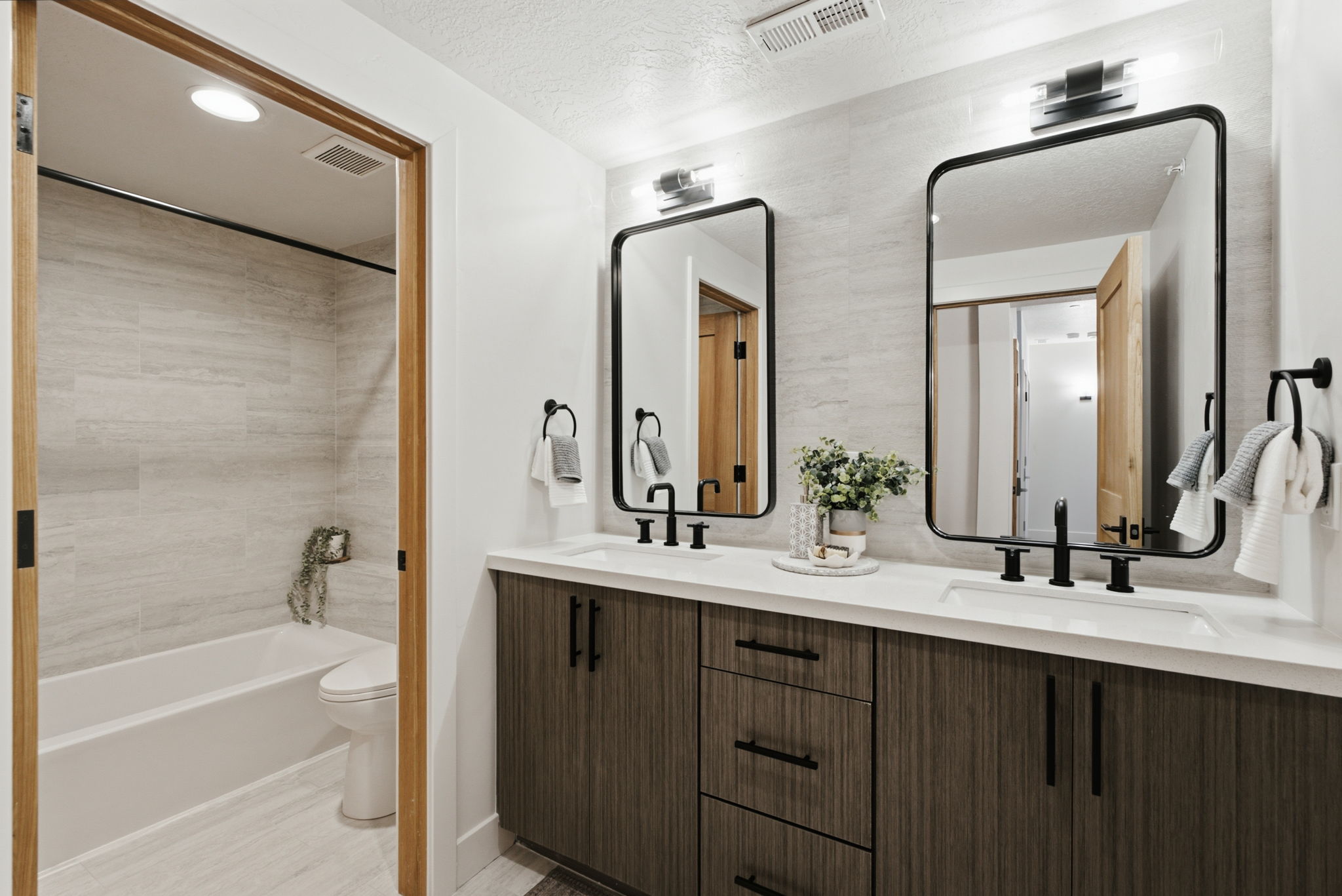 Dual vanity featuring white countertops, undermount sinks, and matte black fixtures
