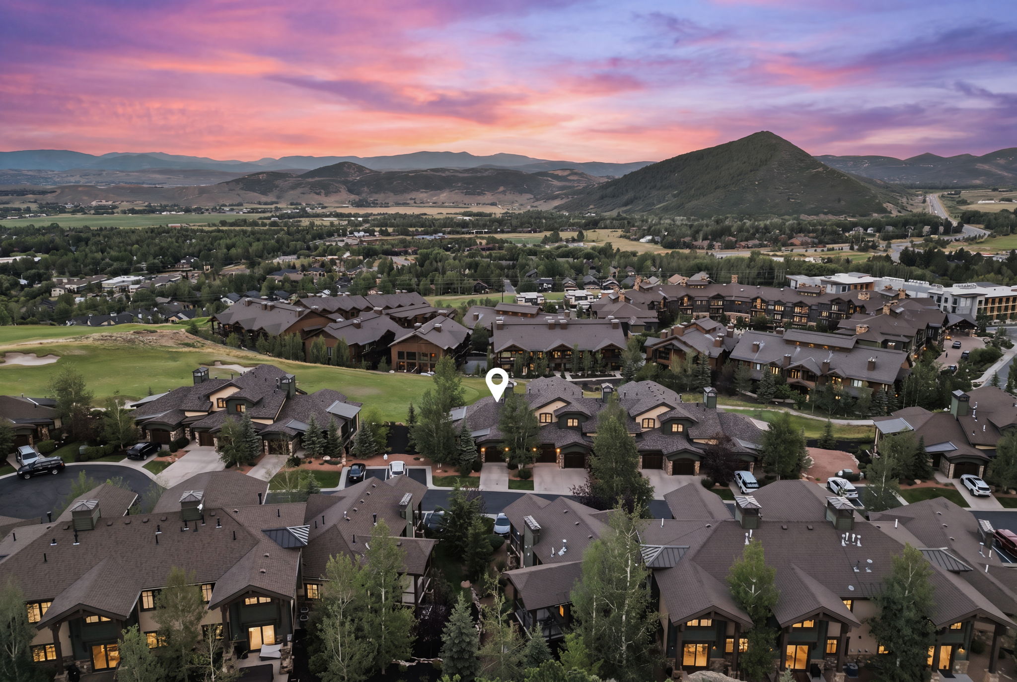 Aerial perspective of a residential community featuring multiple dark-roofed properties