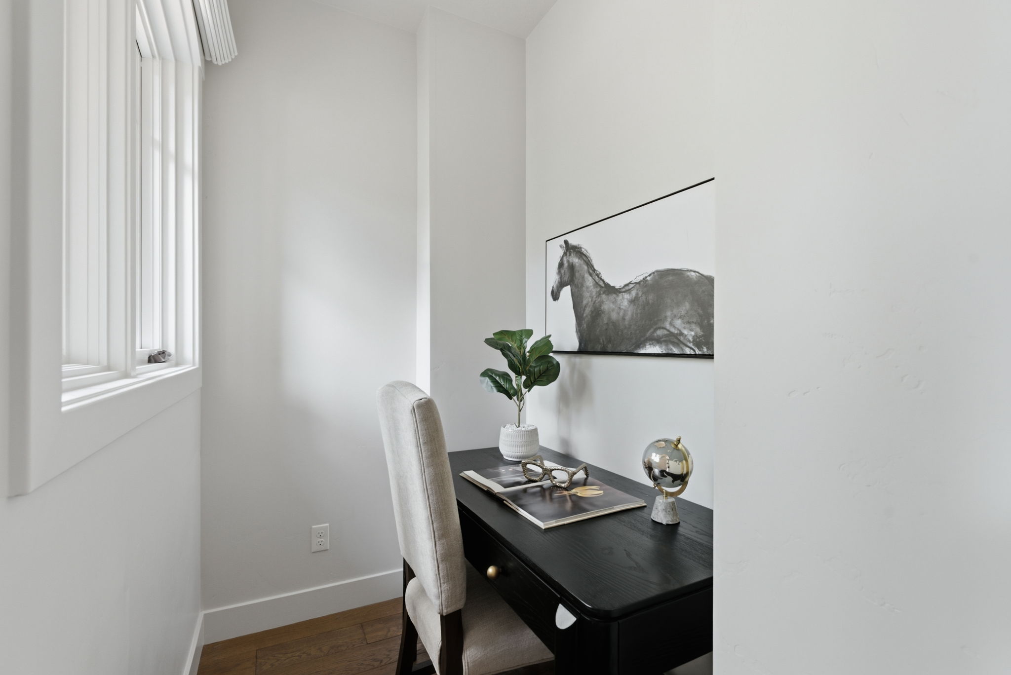 Recessed nook featuring wood-finish flooring, a white trim window, and white walls. Could be used as a small office, mud room, etc