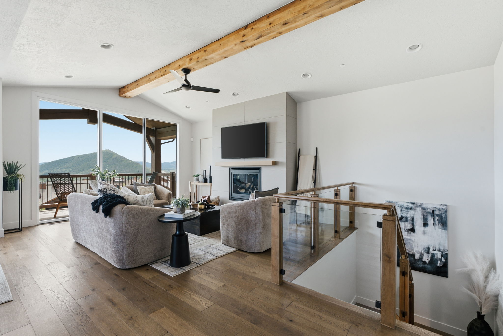 Vaulted ceiling with an exposed wood beam, recessed lighting, and a ceiling fan