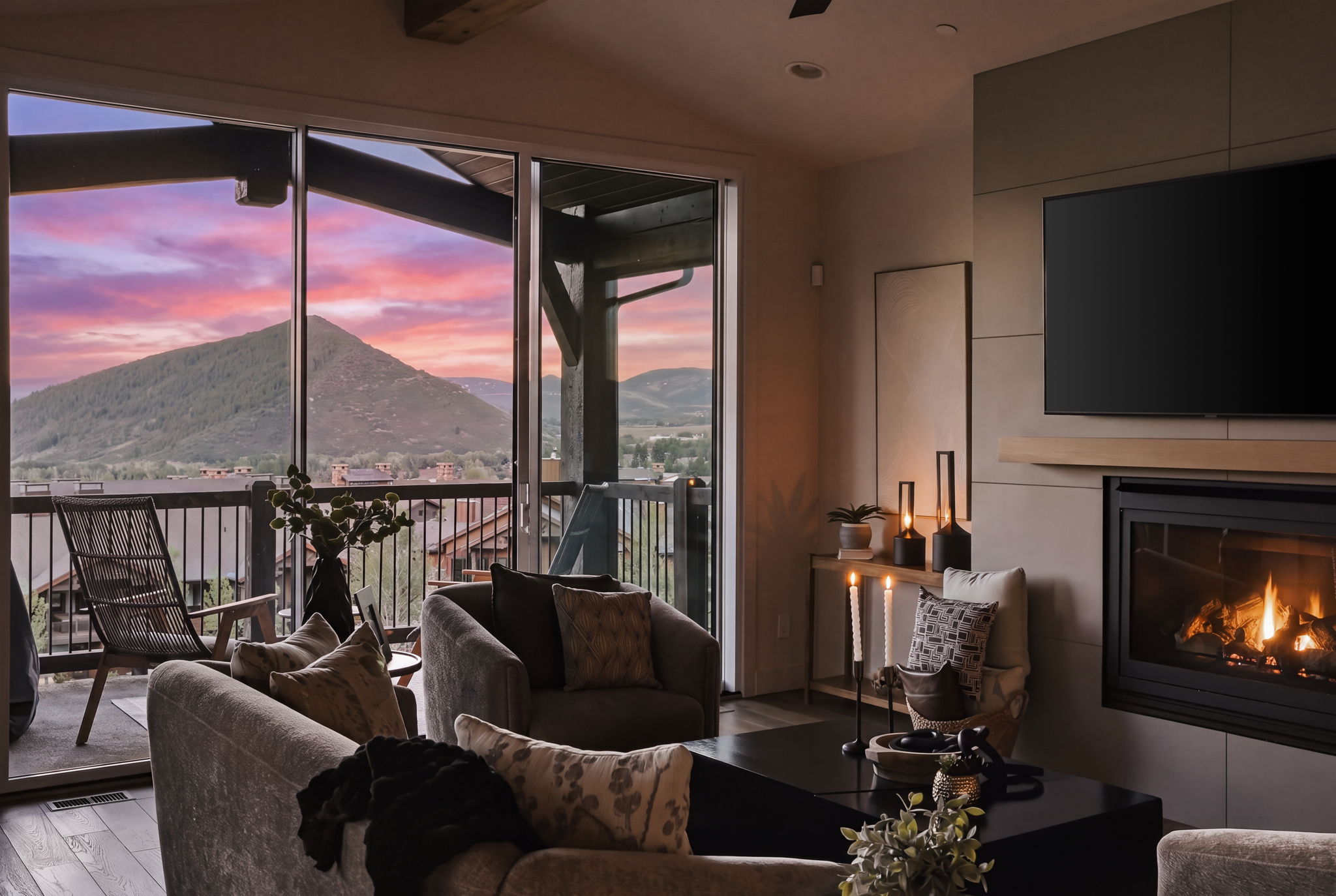 Expansive sliding glass doors opening to a covered balcony, featuring a mountain, golf course, and valley views, and outdoor seating