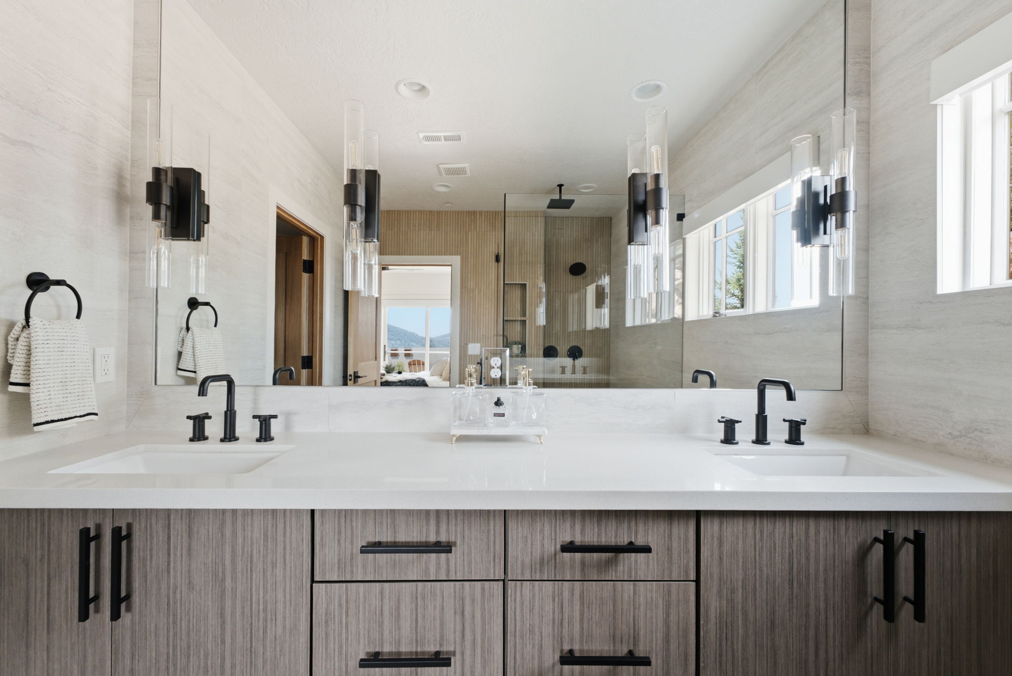 Dual vanity featuring integrated sinks, new fixtures, new countertops, and wood-finish cabinetry