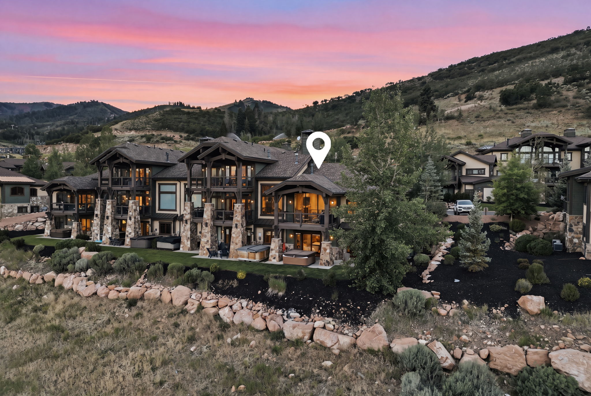 Multi-level residence featuring extensive balconies, stone column accents, and exposed timber framing