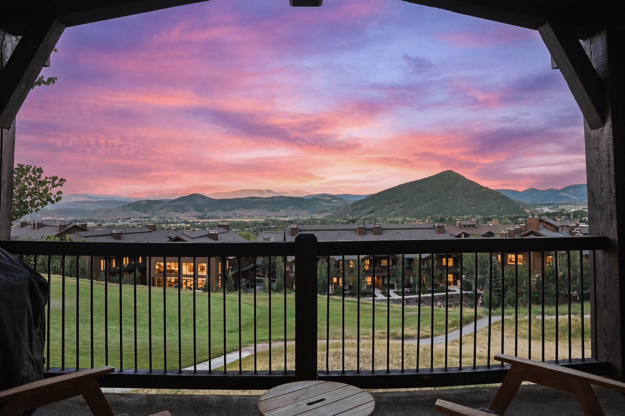 Twilight views, outdoor deck with dark wood railing and metal balusters