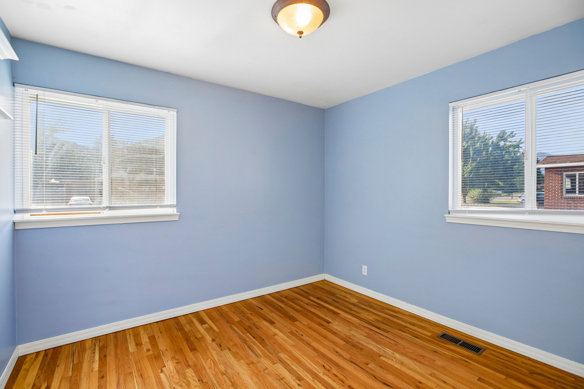 Hardwood flooring, light blue walls, and white trim create a bright aesthetic