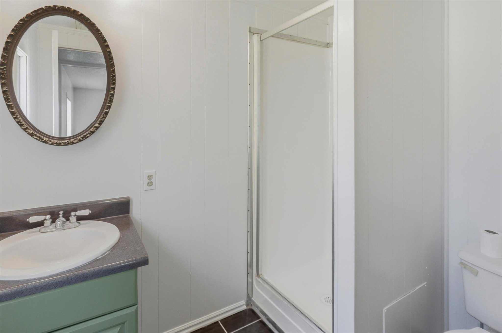 Bathroom featuring a corner shower enclosure and a vanity with an integrated sink