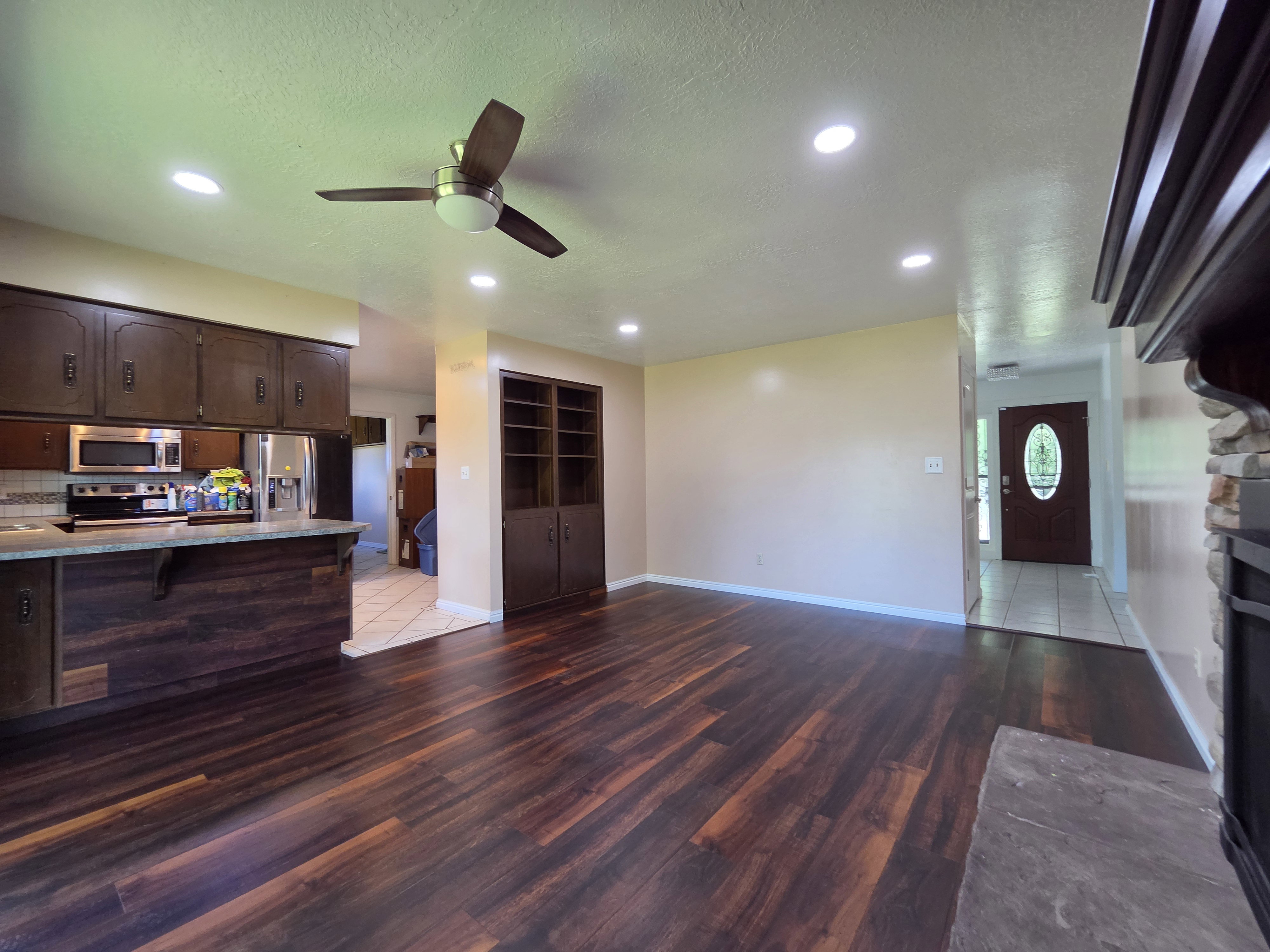 Open-concept living area featuring wood-finish flooring, recessed lighting, and a ceiling fan