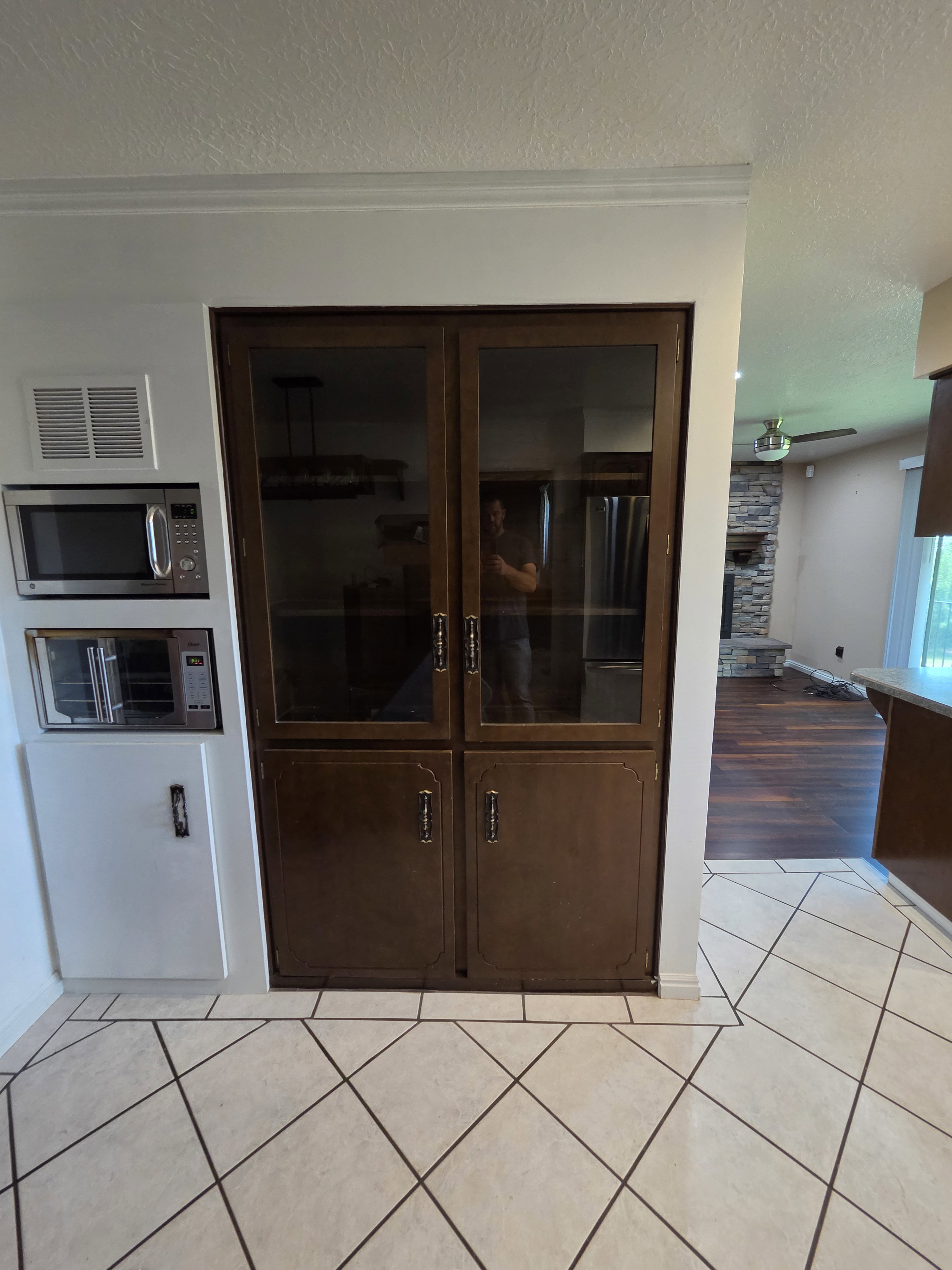 Built-in dark wood cabinetry with glass-paneled upper doors and lower solid doors