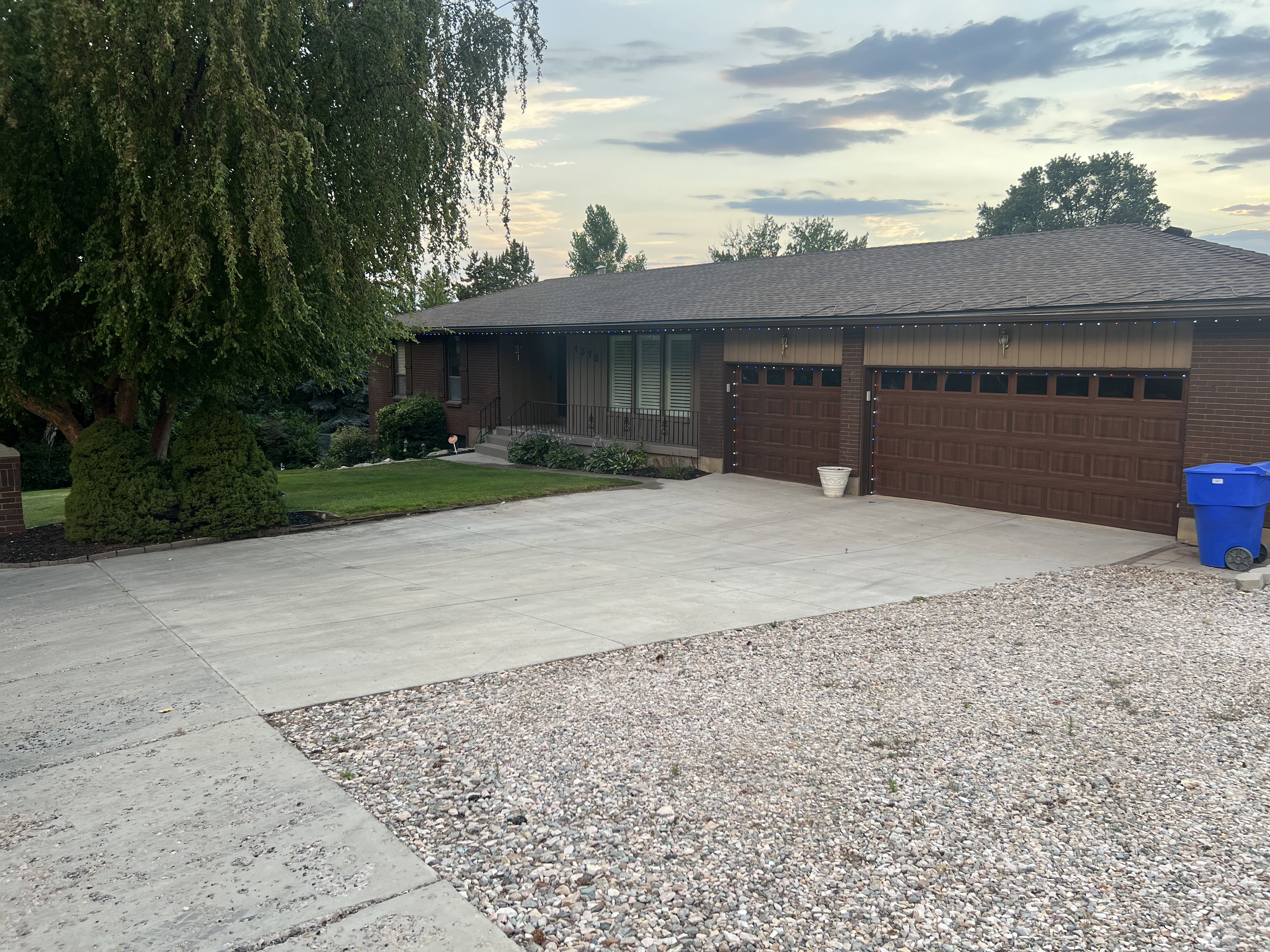 Brick exterior with a brown shingle roof and a two-car garage