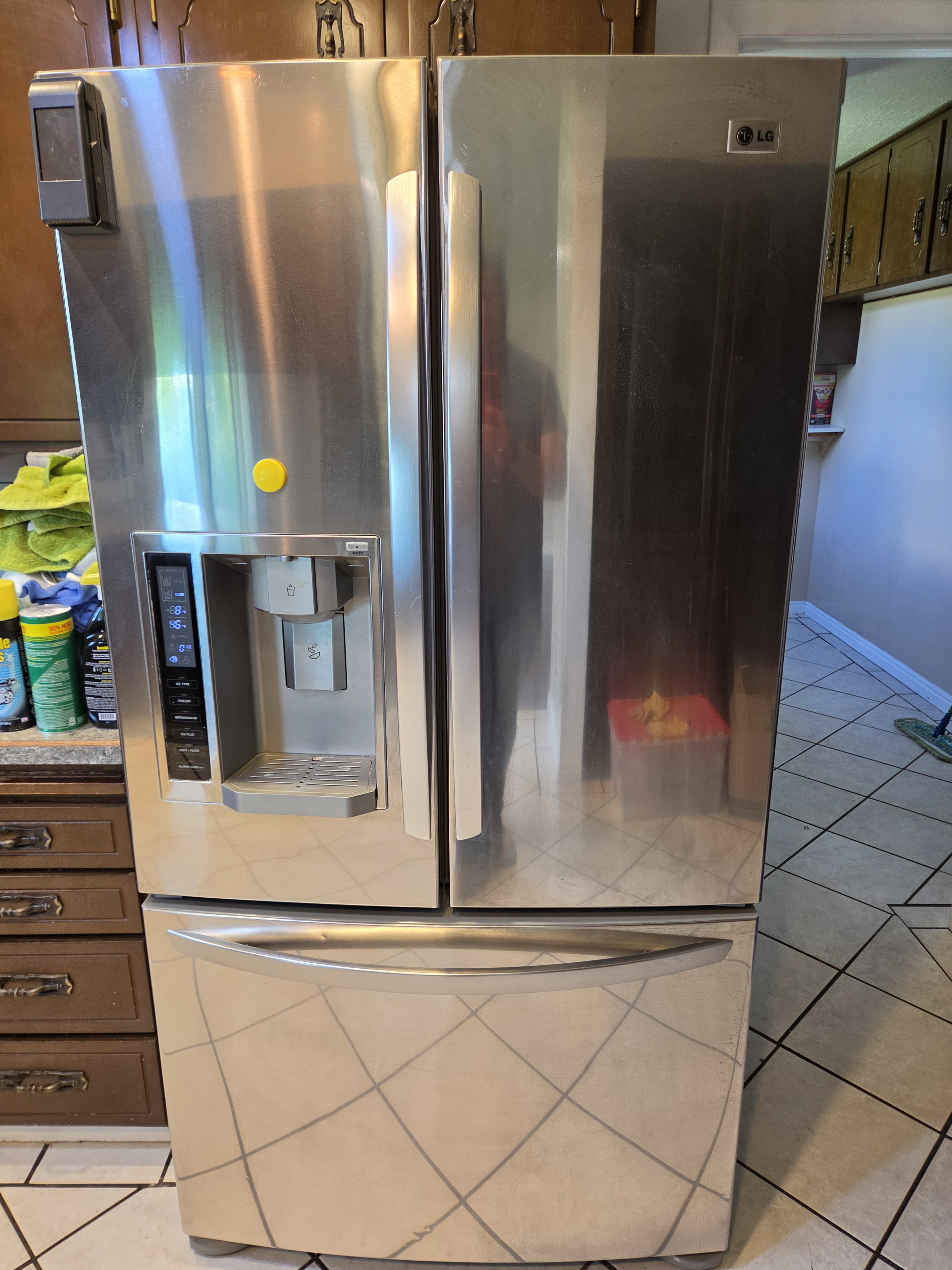 Stainless steel French door refrigerator featuring an integrated ice and water dispenser and bottom freezer drawer
